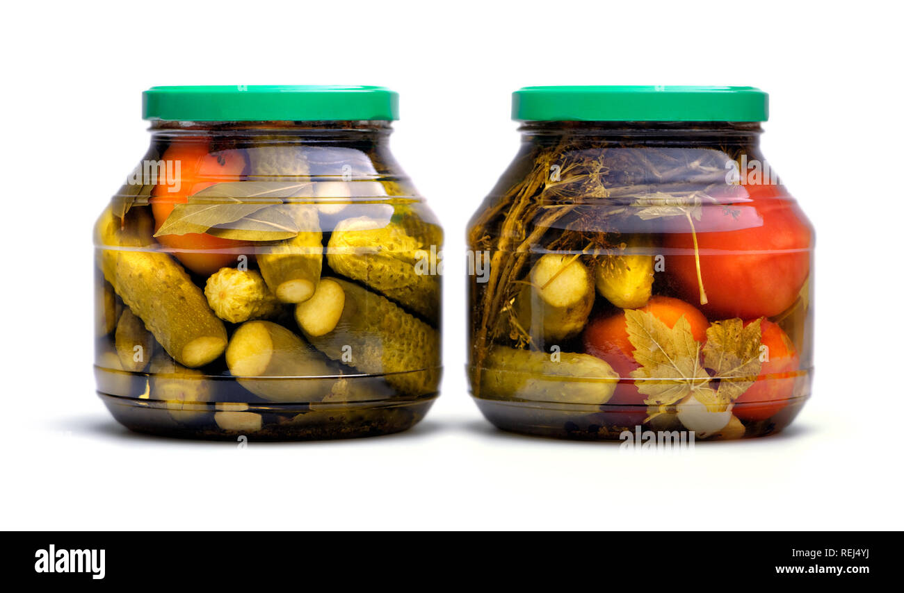 Cibo e bevande: conserve fatte in casa, cetrioli sottaceto e pomodori in un vasetto di vetro, isolati su sfondo bianco Foto Stock