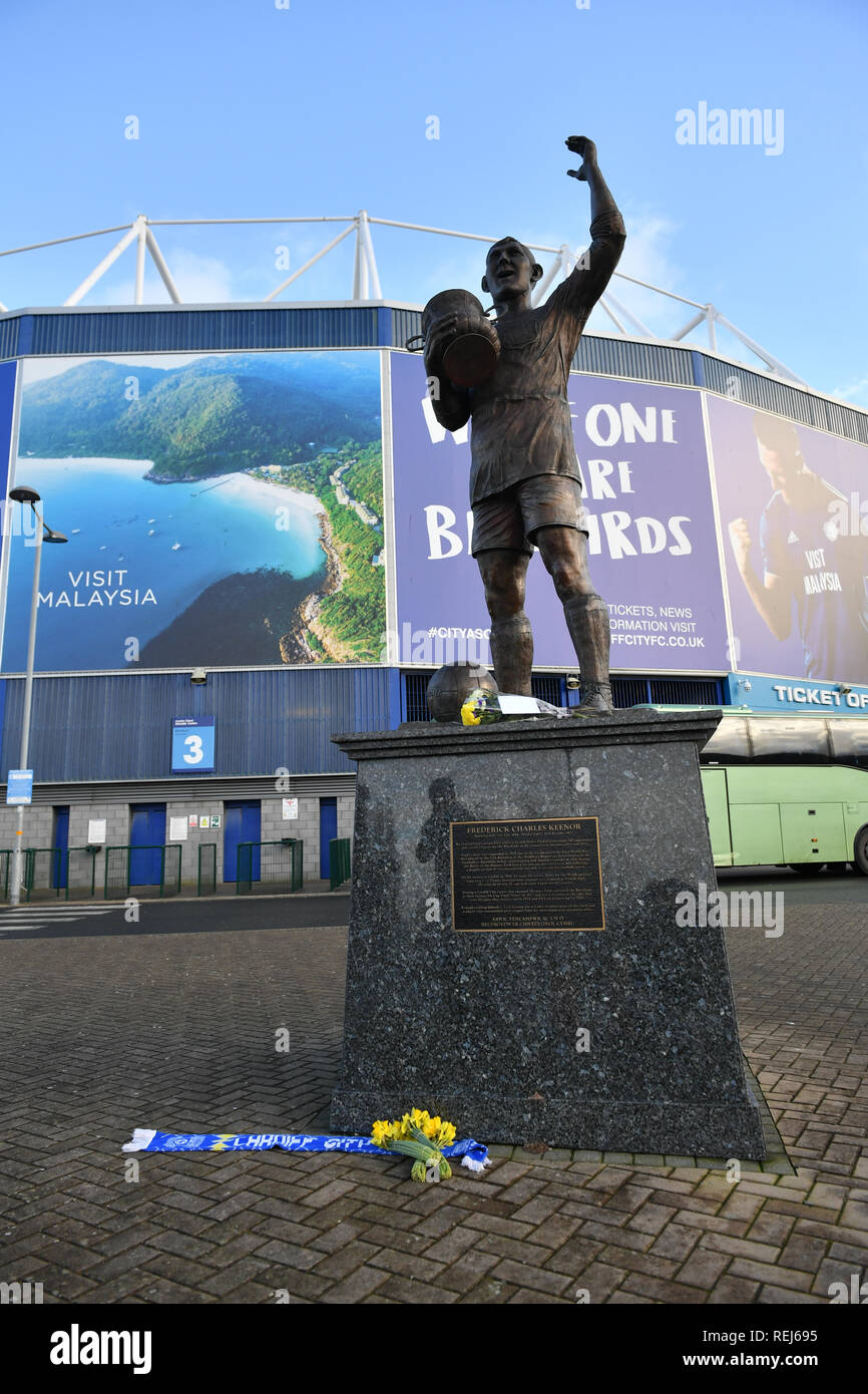 Fiori sulla sinistra la statua di Cardiff City il calciatore Frederick Charles Keenor fuori Cardiff City Football Club dopo un piano con nuova firma Emiliano Sala a bordo sono scomparsi oltre la Manica di lunedì sera. Foto Stock