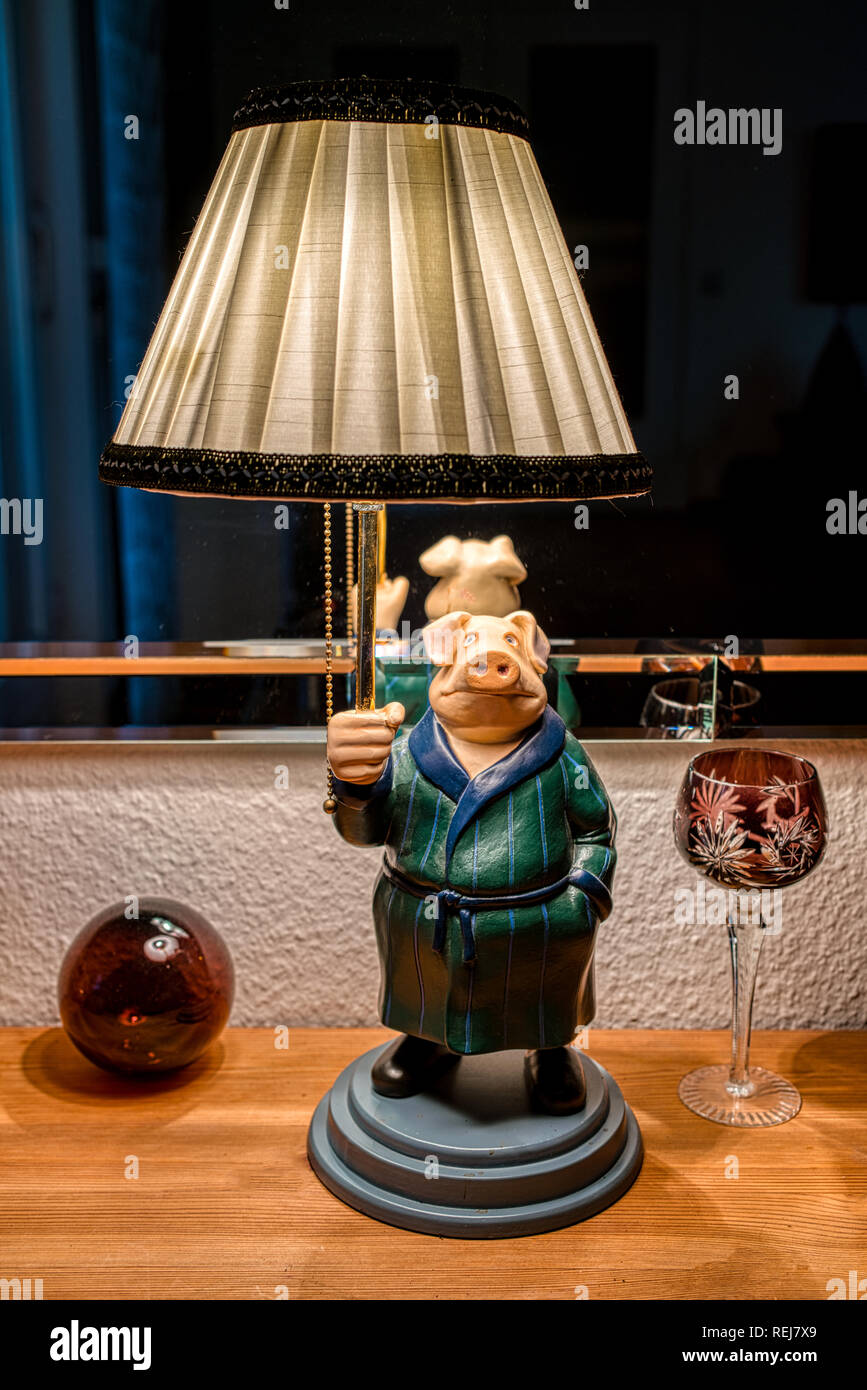 Elettrico verticale lampada da tavolo guardando come un maiale con lampada tessile di ombra e di uno specchio come sfondo Foto Stock