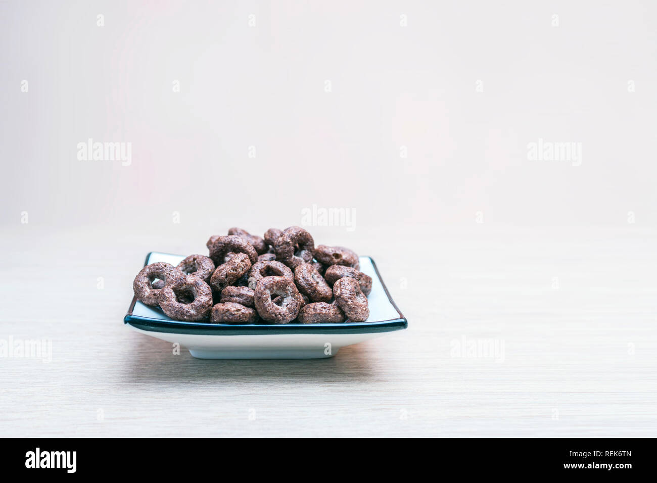 Croccante granella intera di cioccolato Round dei cereali di avena in un quadrato piatto luce sul tavolo di legno. Sani Snack organico, il cibo, la colazione concetto con Copy-Spac Foto Stock