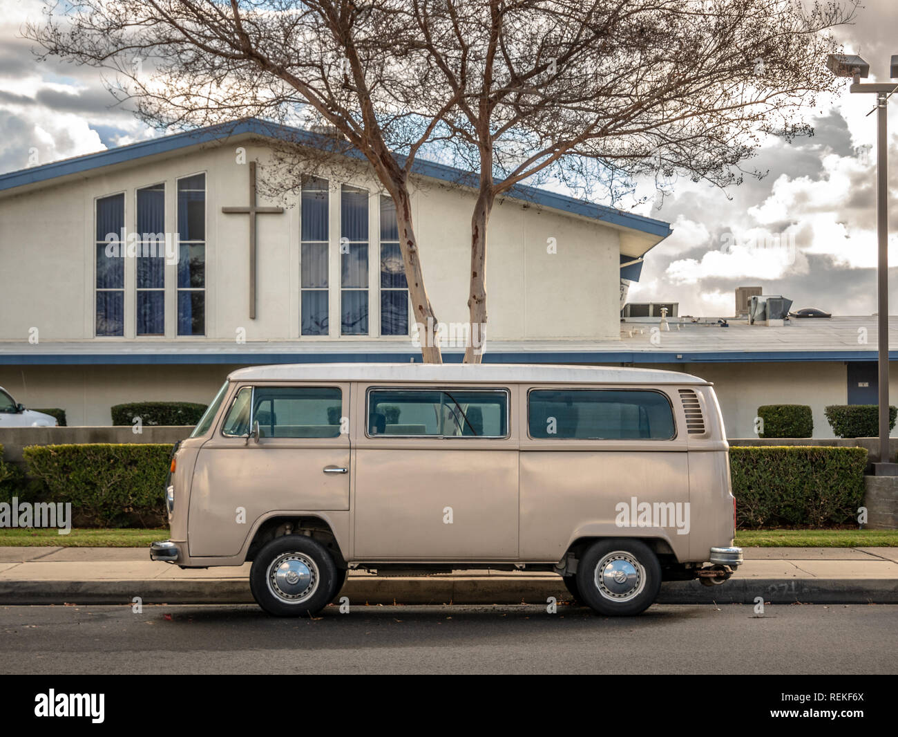 Un vintage bus VW parcheggiato sulla strada di fronte alla chiesa. Foto Stock