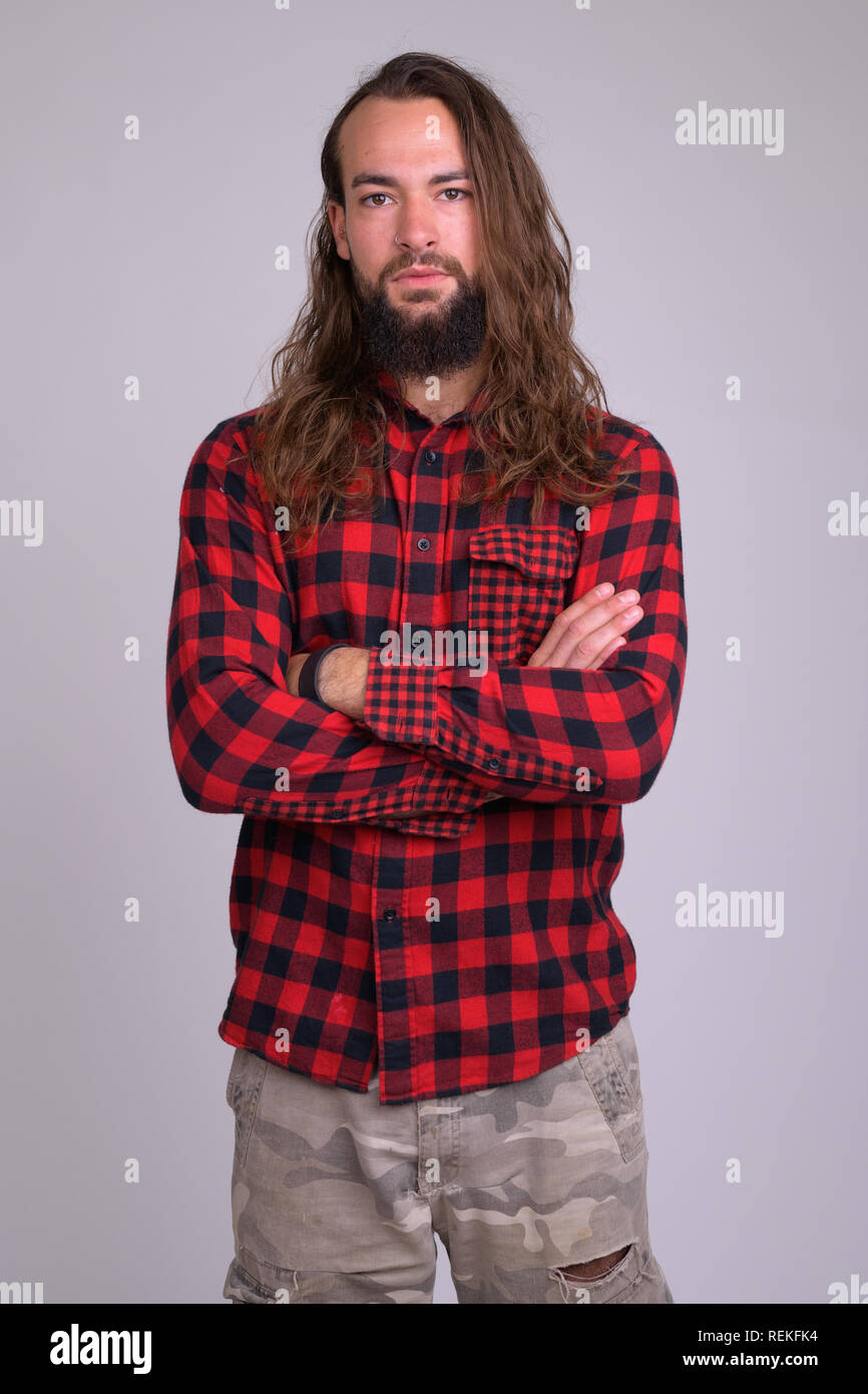 Ritratto di giovane bello barbuto hipster uomo con le braccia incrociate Foto Stock