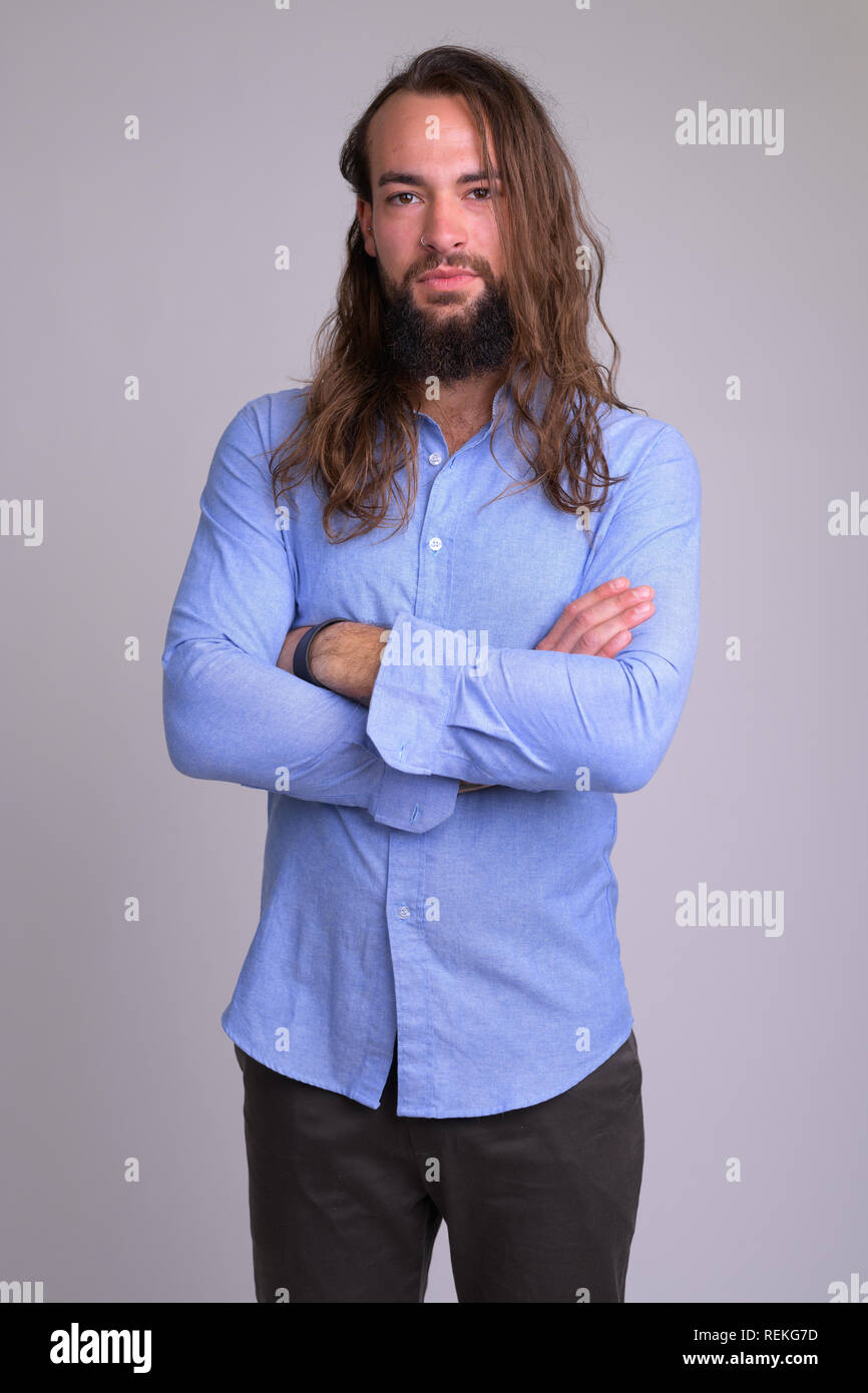 Ritratto di giovane bello barbuto imprenditore con le braccia incrociate Foto Stock