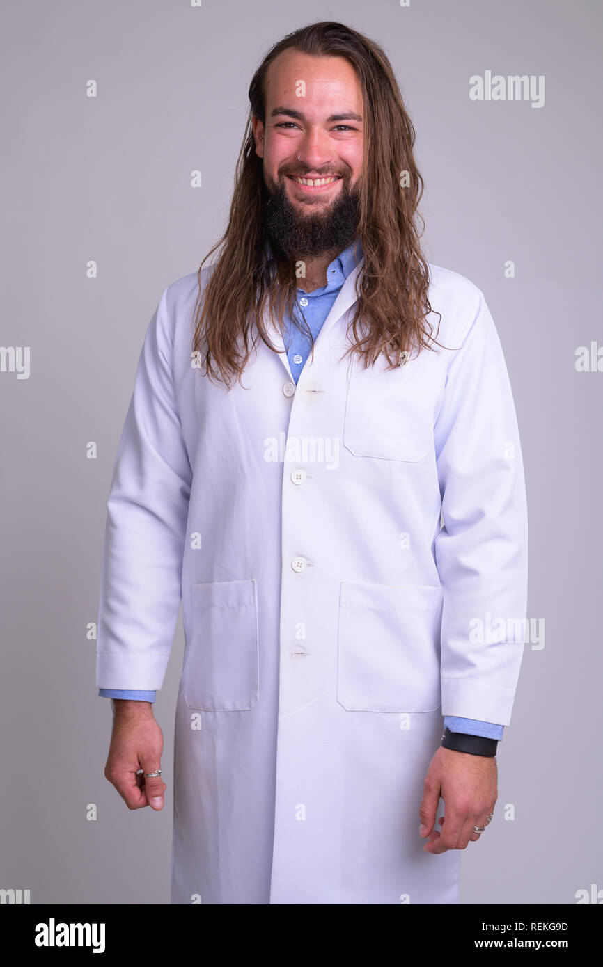 Ritratto di giovane felice uomo barbuto medico sorridente Foto Stock