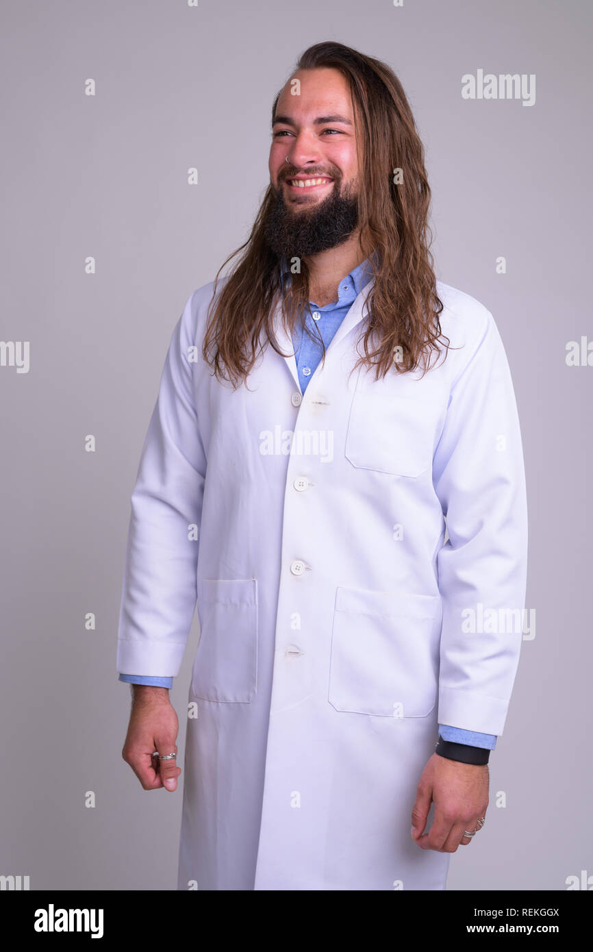 Ritratto di giovane felice uomo barbuto pensiero medico Foto Stock