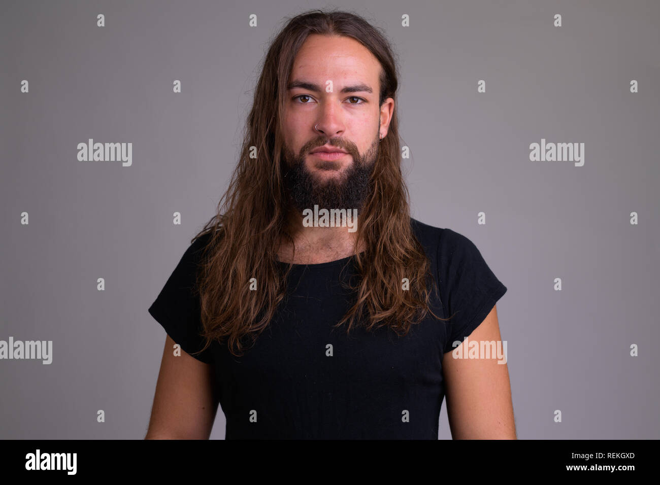 Ritratto di giovane bello uomo barbuto con i capelli lunghi Foto Stock
