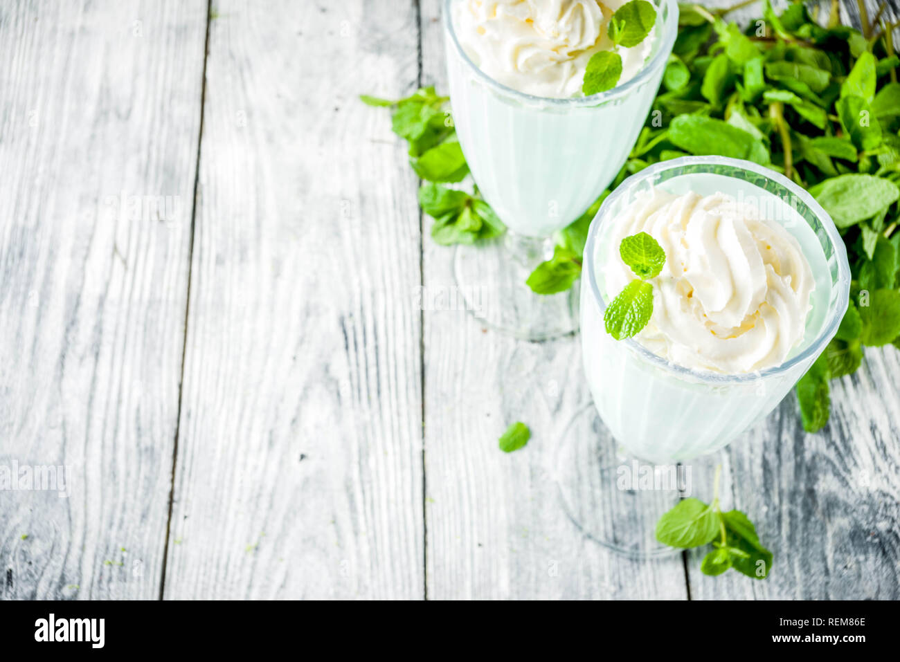 Estate cocktail rinfrescante, shamrock mint agitare, dolce bere latte con foglie di menta fresca, sullo sfondo di legno spazio copia Foto Stock