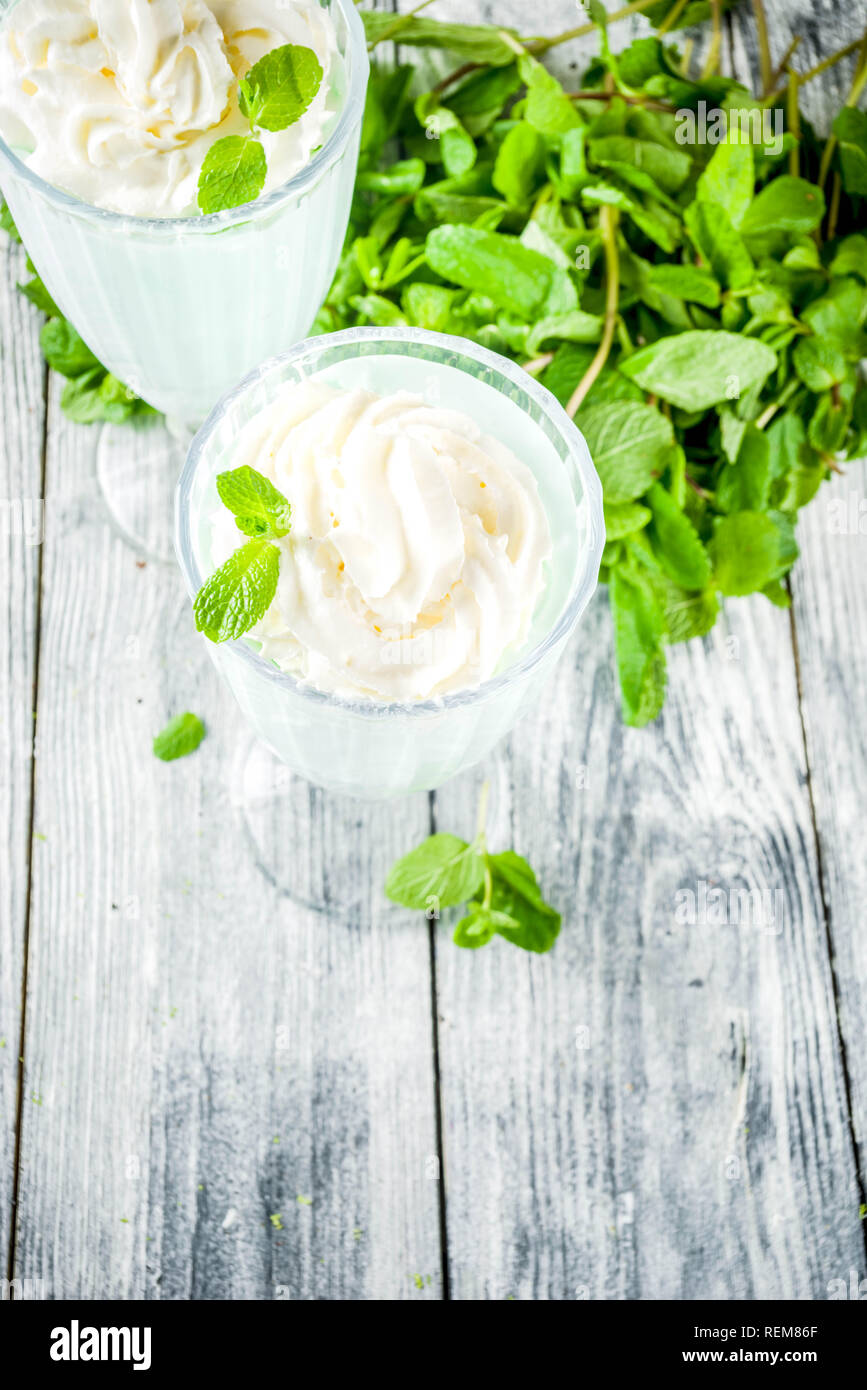 Estate cocktail rinfrescante, shamrock mint agitare, dolce bere latte con foglie di menta fresca, sullo sfondo di legno spazio copia Foto Stock