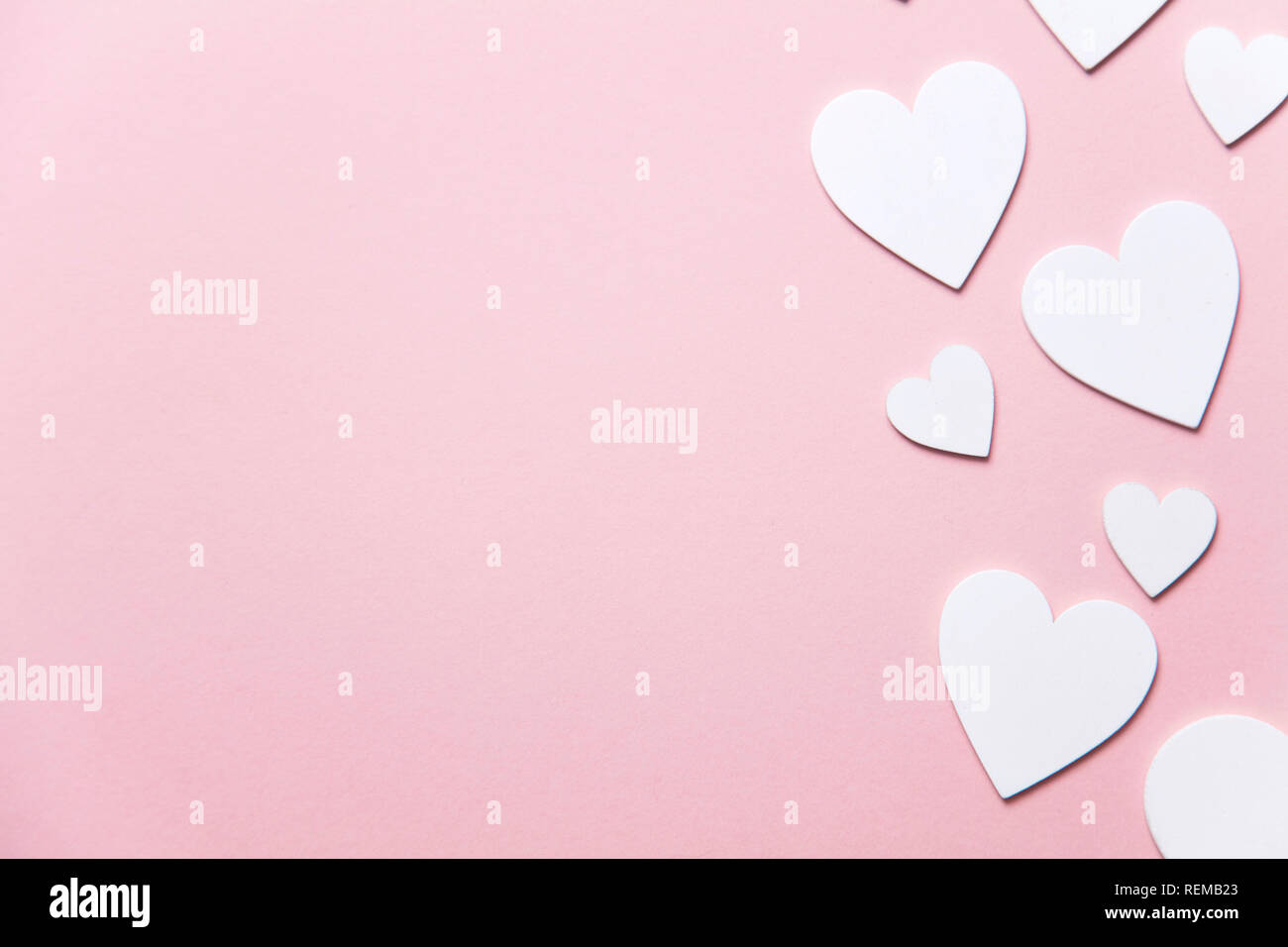 Cuori di colore bianco su un pastello sfondo rosa. Foto Stock