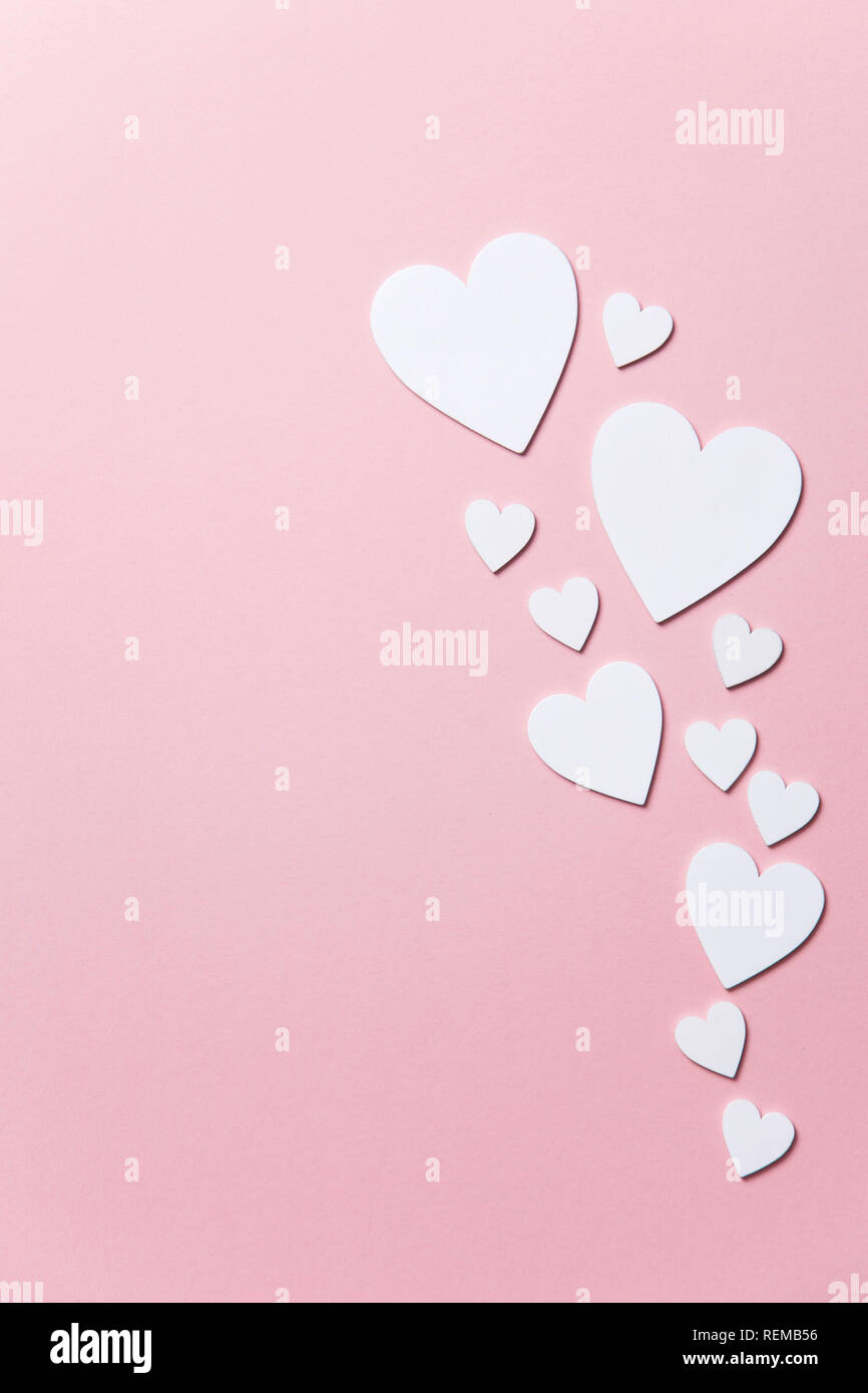 Cuori di colore bianco su un pastello sfondo rosa. Foto Stock
