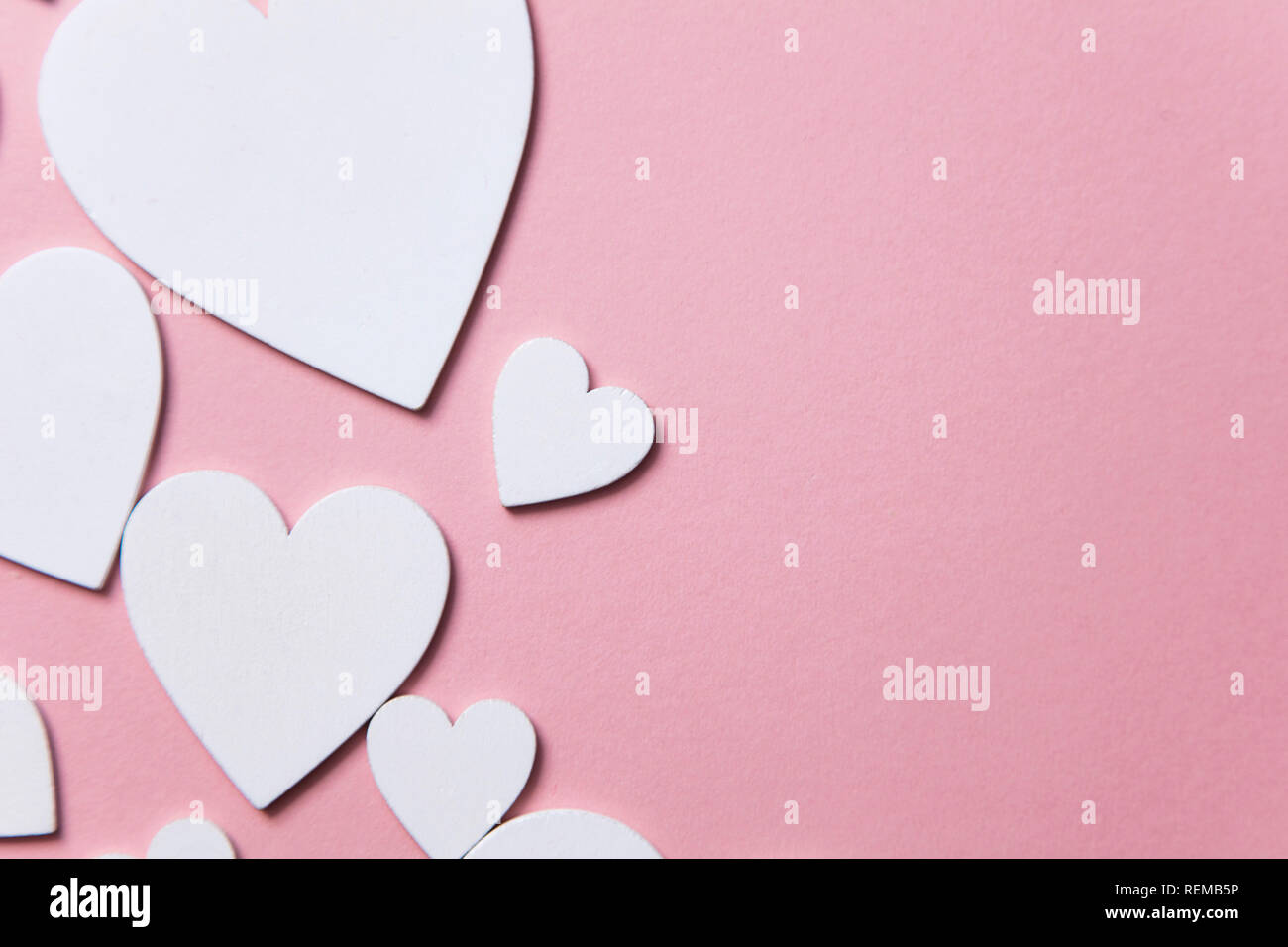 Cuori di colore bianco su un pastello sfondo rosa. Foto Stock