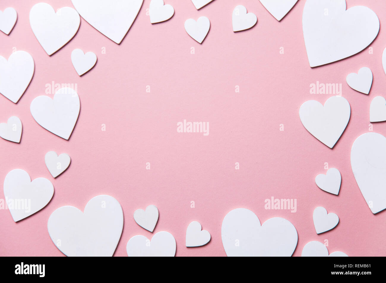 Cuori di colore bianco su un pastello sfondo rosa. Foto Stock