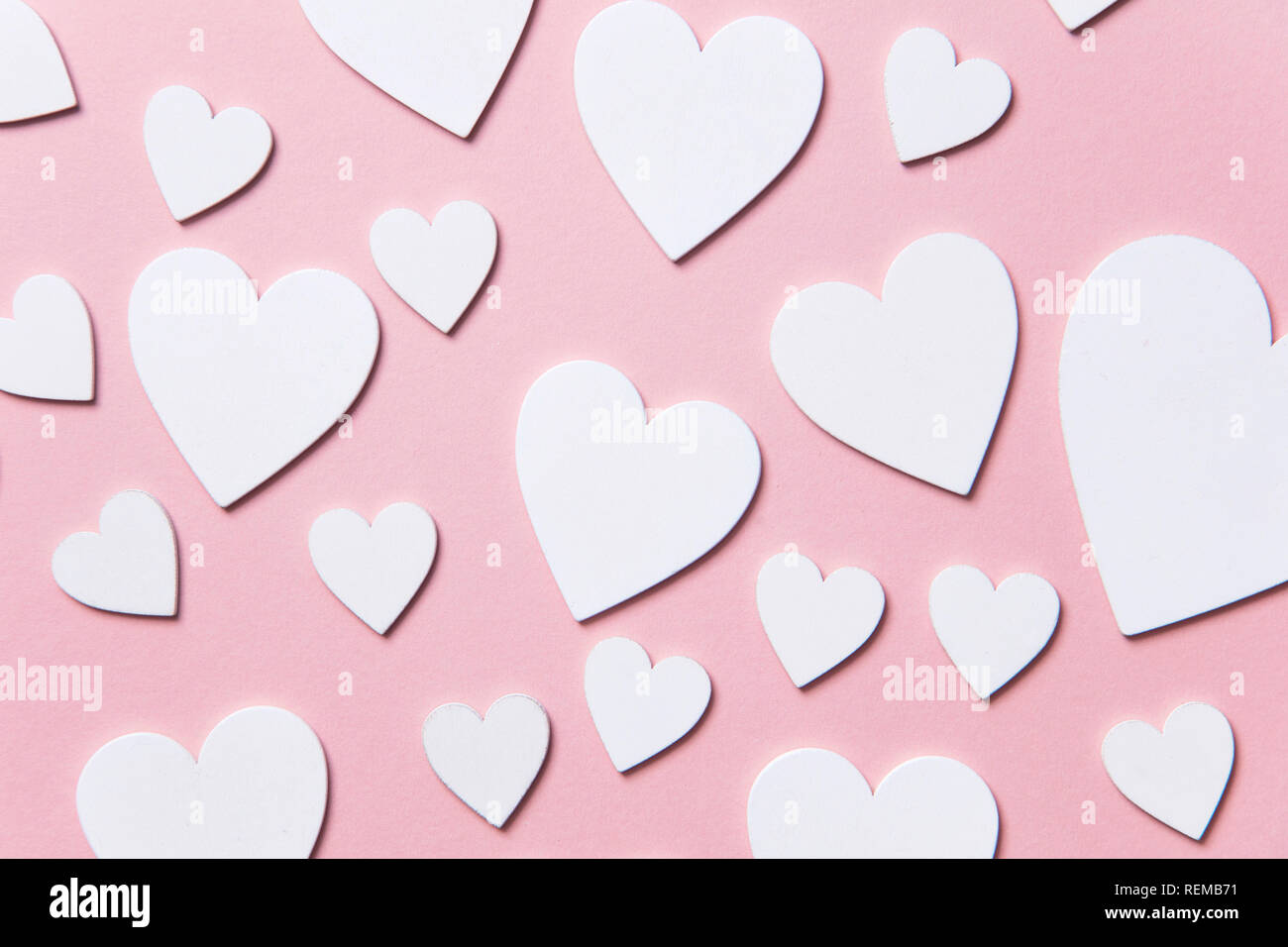 Cuori di colore bianco su un pastello sfondo rosa. Foto Stock