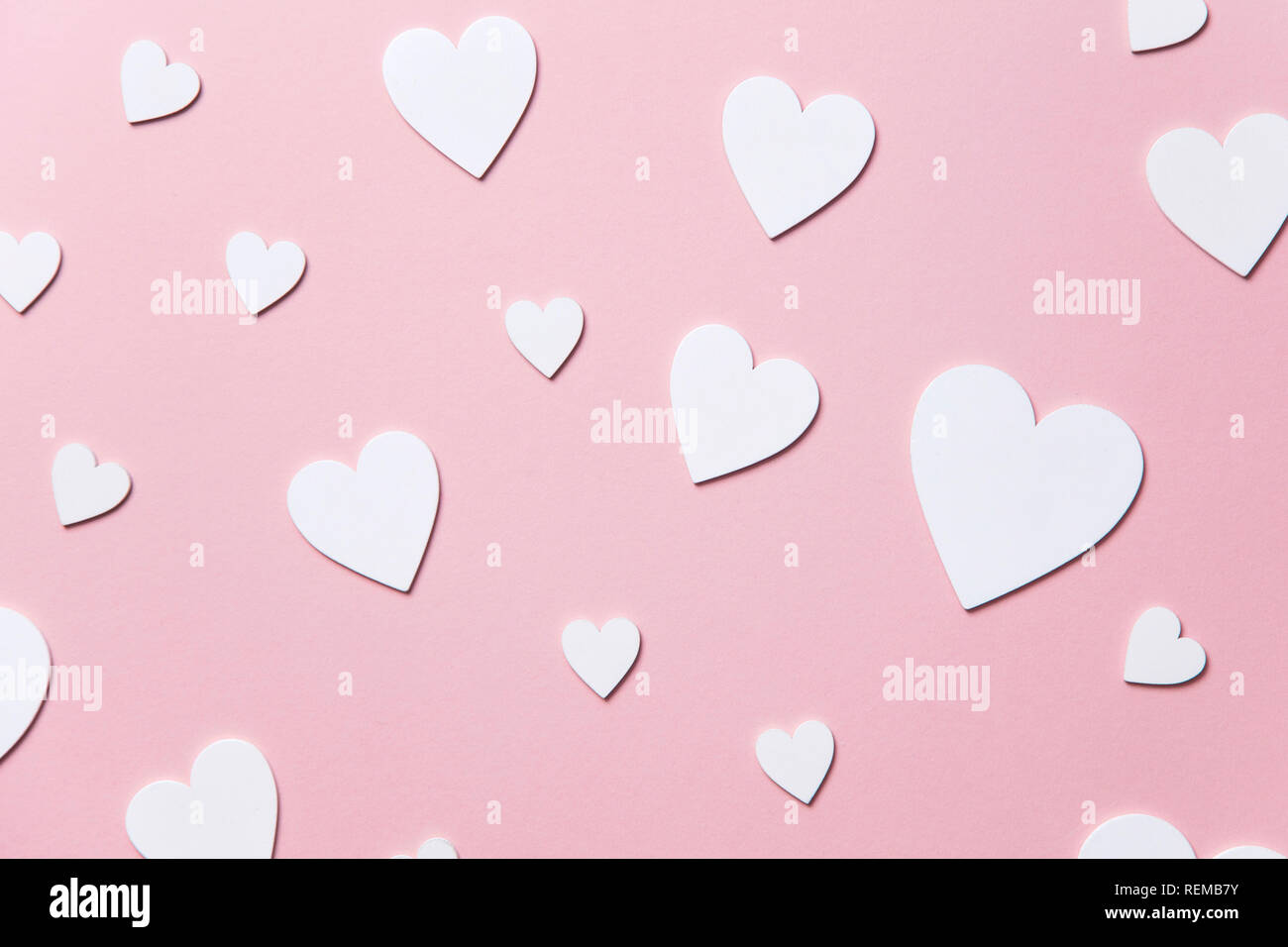 Cuori di colore bianco su un pastello sfondo rosa. Foto Stock