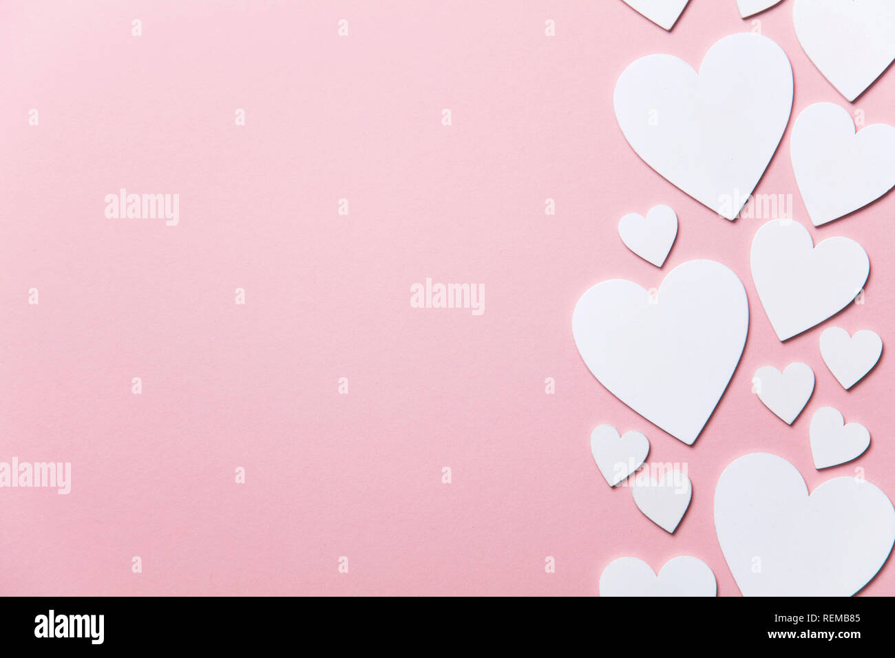 Cuori di colore bianco su un pastello sfondo rosa. Foto Stock