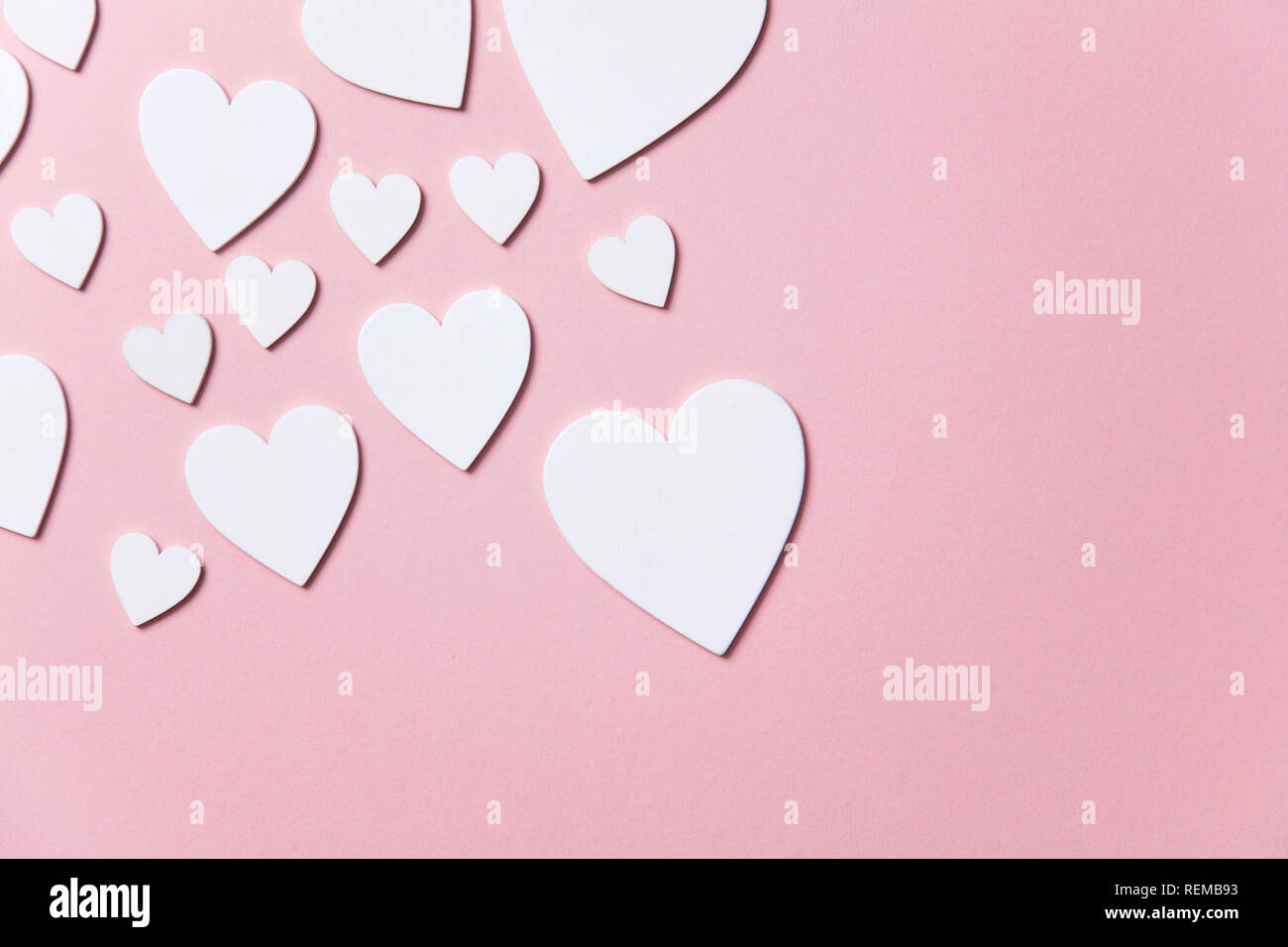 Cuori di colore bianco su un pastello sfondo rosa. Foto Stock