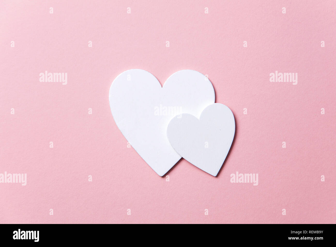 Cuori di colore bianco su un pastello sfondo rosa. Foto Stock