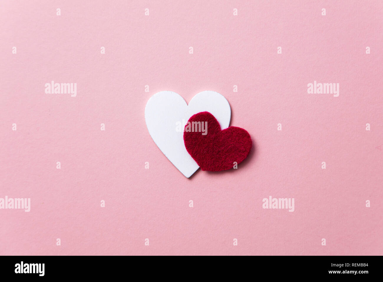 Cuori di colore bianco su un pastello sfondo rosa. Foto Stock