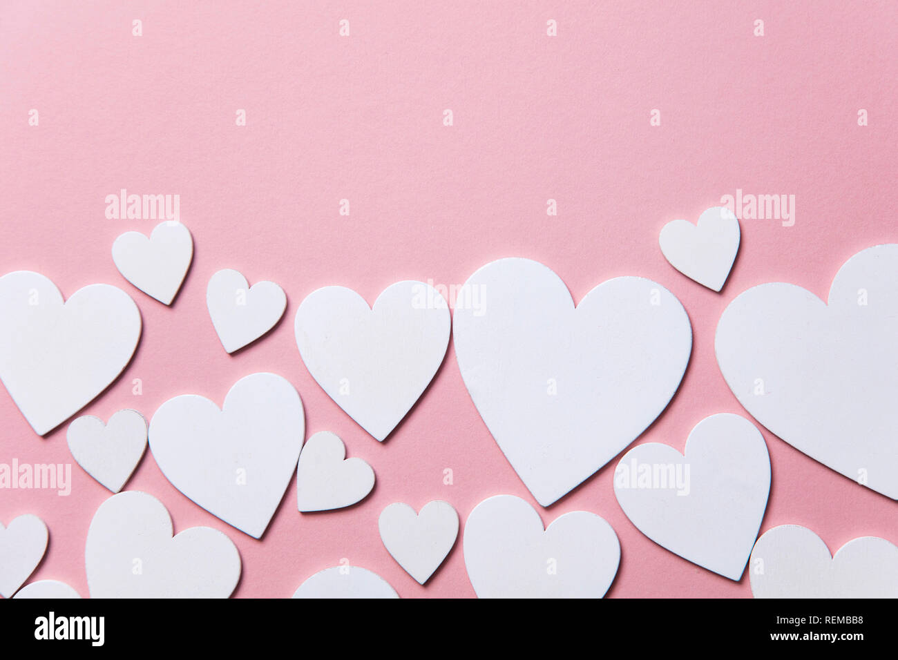 Cuori di colore bianco su un pastello sfondo rosa. Foto Stock