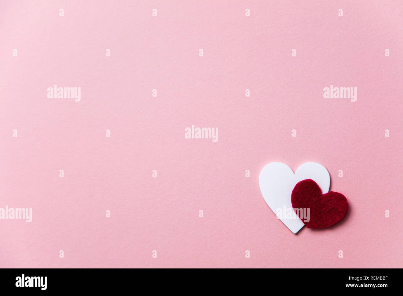 Cuori di colore bianco su un pastello sfondo rosa. Foto Stock