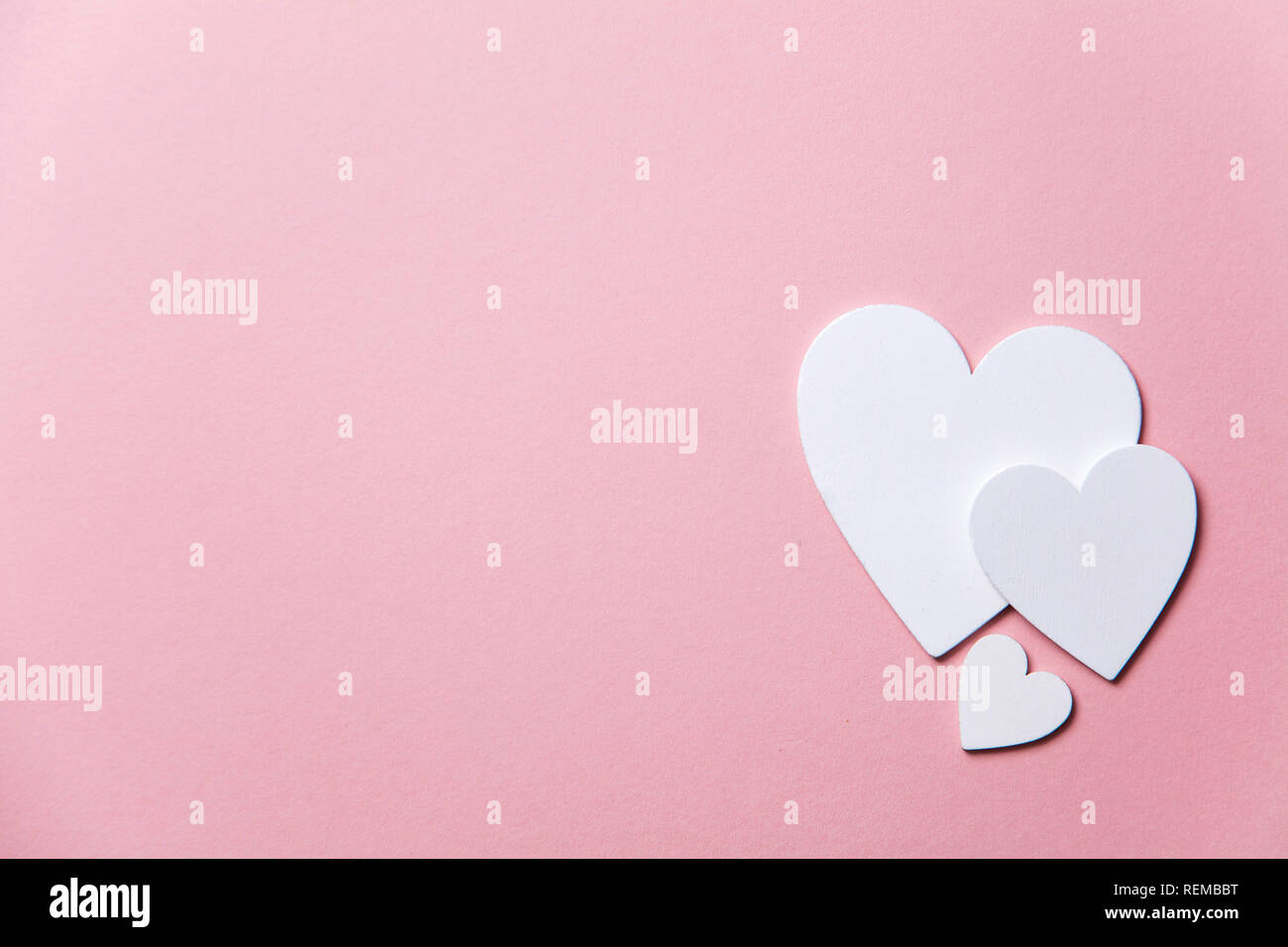 Cuori di colore bianco su un pastello sfondo rosa. Foto Stock