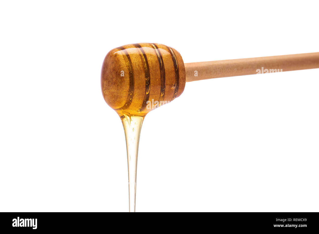 Il miele che gocciola dalla cucchiaia isolato su sfondo bianco. Foto Stock