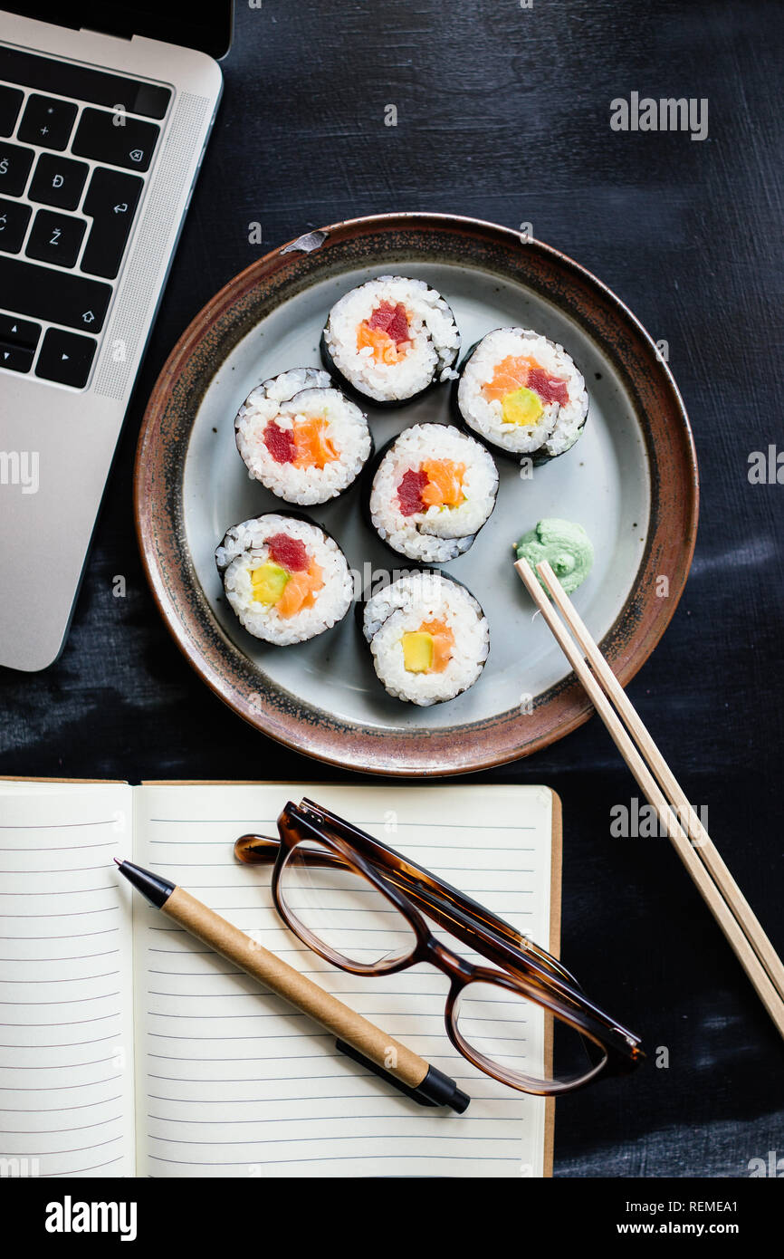 Laptop e rotoli di sushi con wasabi al lavoro Foto Stock