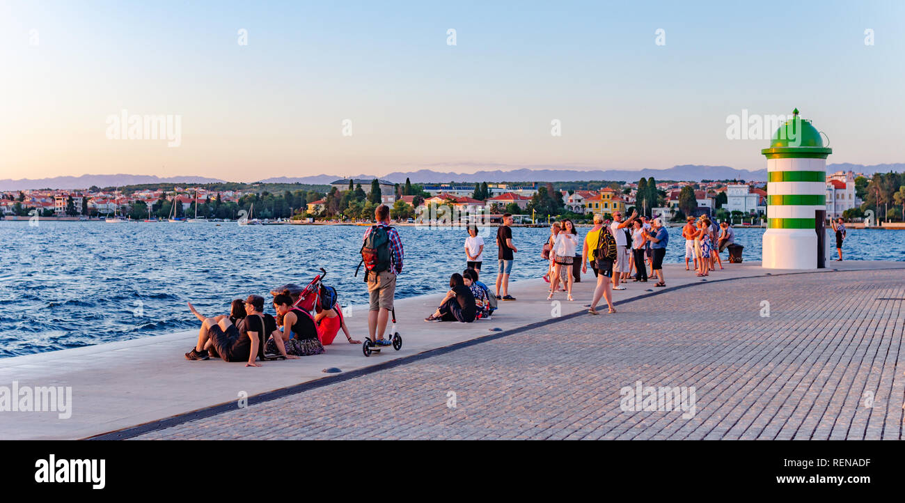 Mare Adriatico terrapieno con un faro e turisti in estate in Zadar, Croazia. Foto Stock