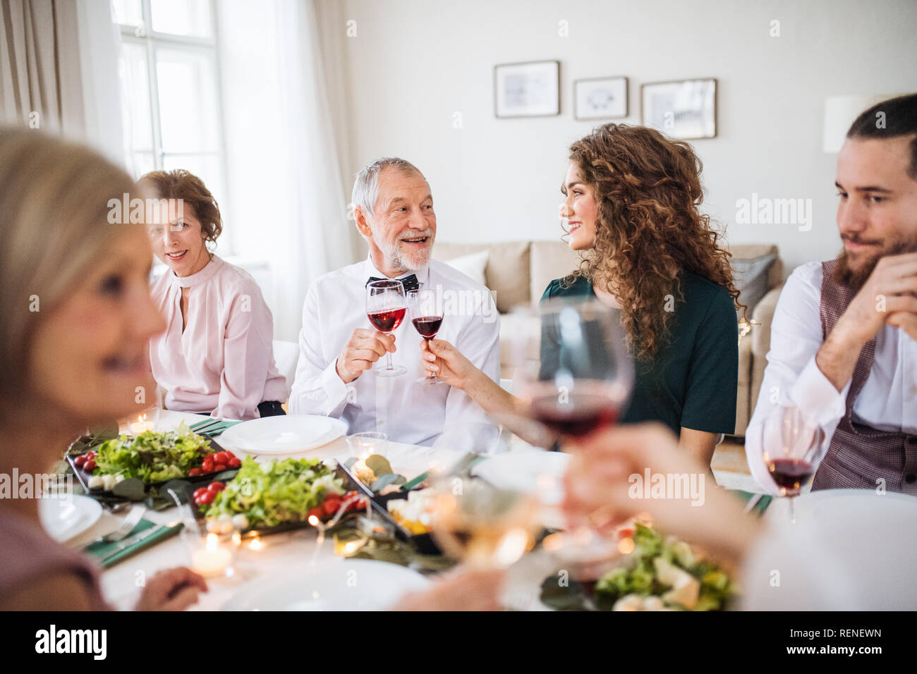 Una grande famiglia seduti a un tavolo in una piscina festa di compleanno, bicchieri tintinnanti. Foto Stock