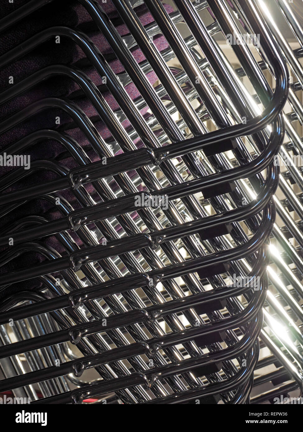 Disco modello geometrico di sovrapposizione impilati in tubolare di acciaio sedie incorniciati in albero del sole brillante inCumbria, England, Regno Unito Foto Stock