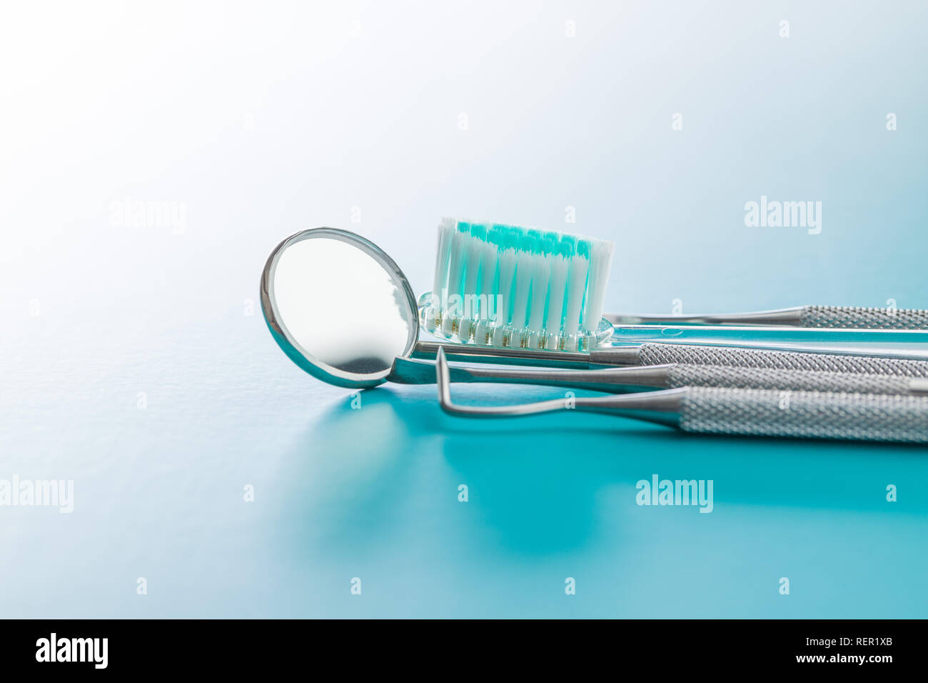 Strumenti odontoiatrici. Strumenti di dentisti e spazzolino su sfondo blu. Foto Stock