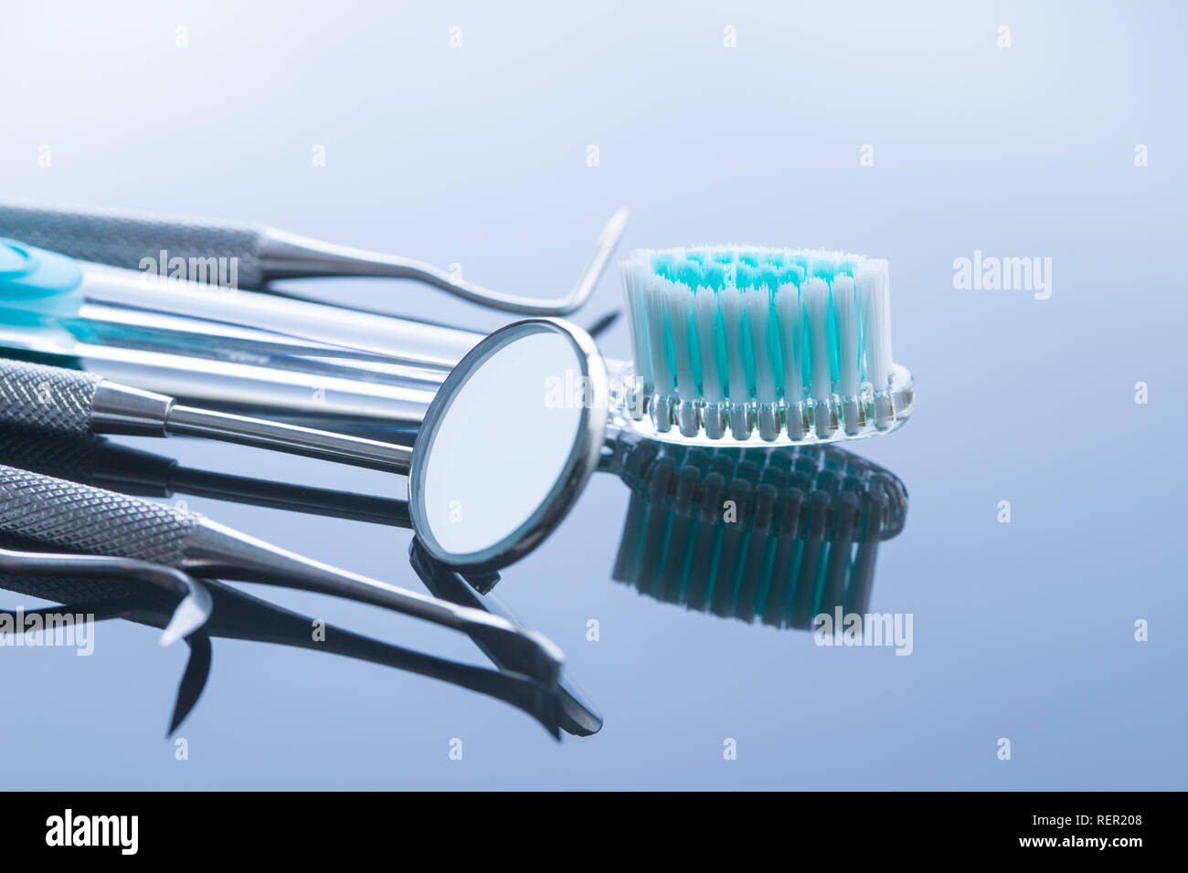 Strumenti odontoiatrici. Strumenti di dentisti e spazzolino su sfondo a specchio. Foto Stock