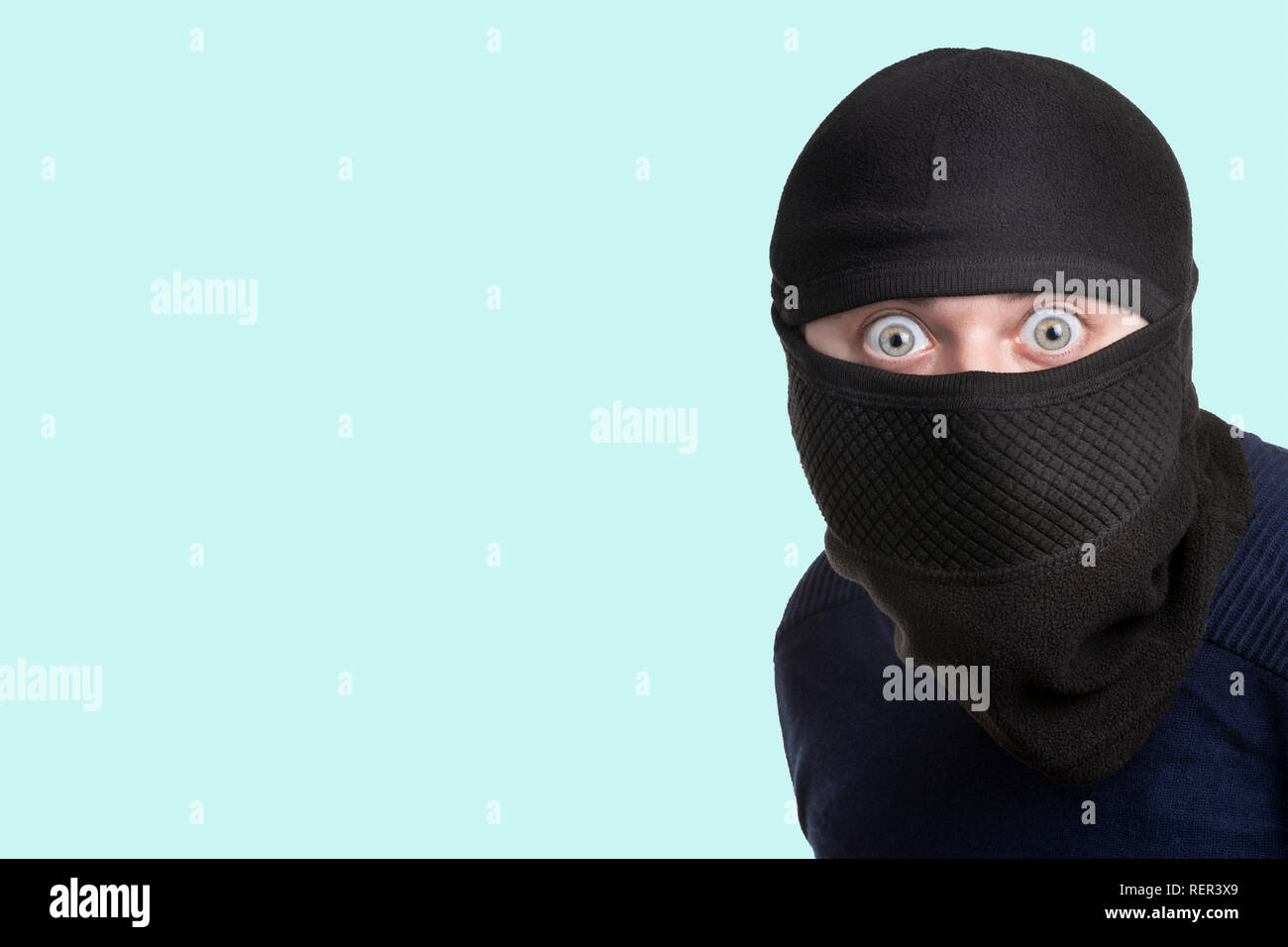 Uomo in un passamontagna su uno sfondo blu, il concetto di cattura di un  criminale in una scena del crimine Foto stock - Alamy