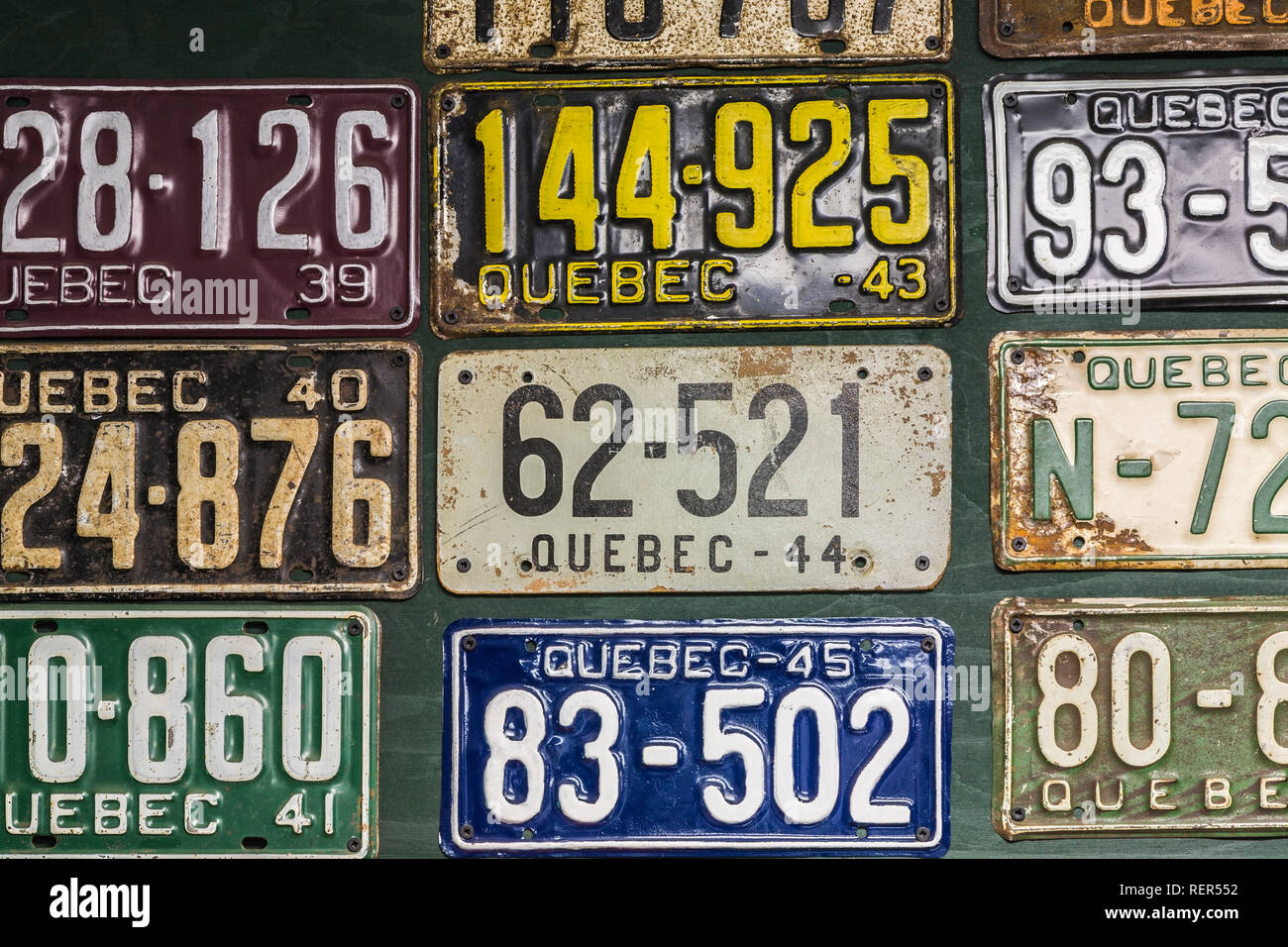 Colorata collezione vintage di Quebec automobile targhe sulla parete del garage all'interno di un vecchio 1927 Canadiana cottage in stile home Foto Stock