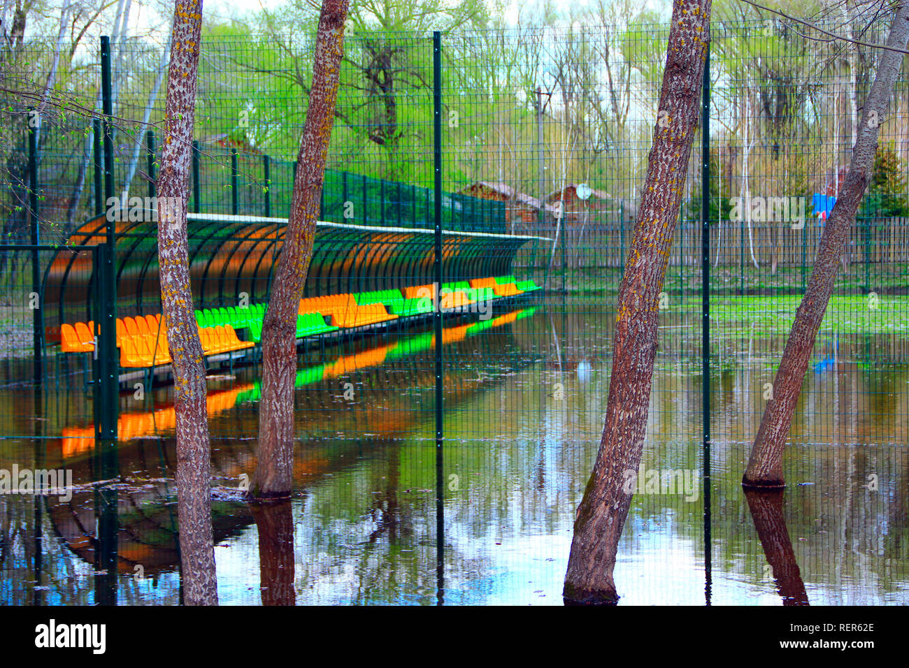 Campo di calcio durante la piena del fiume. Piccolo stadio di calcio recintato con net è allagato con acqua durante l'alluvione. Il calcio ha preso break Foto Stock