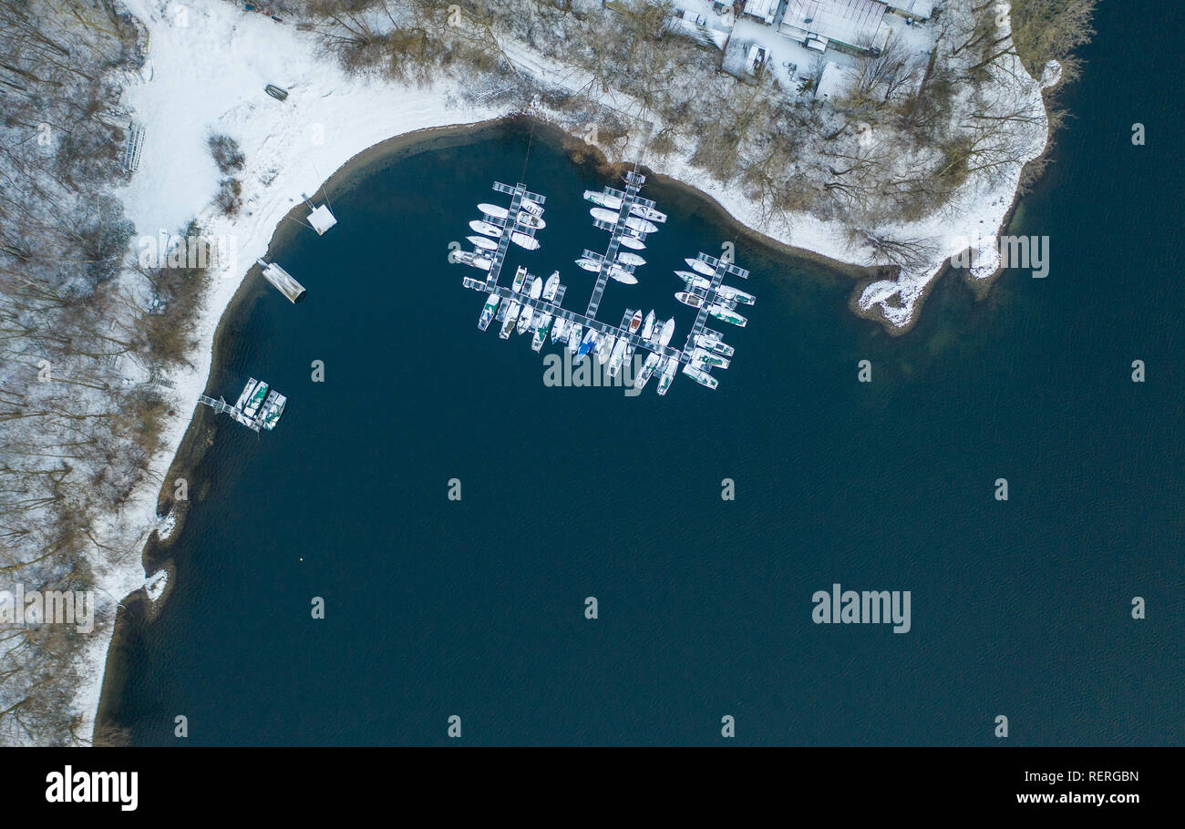 A Monheim am Rhein, Germania. 23 gen 2019. Coperte di neve ormeggia presso un pontile sulla Monheim quarry pond. (Fotografia aerea con drone) Credito: Christophe Gateau/dpa/Alamy Live News Foto Stock