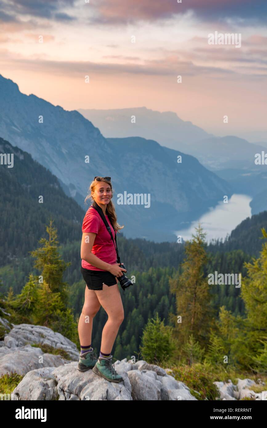 Escursionista guarda nella telecamera, vista sul Königssee dal Feldkogel, sinistra Watzmann e Südspitze Watzmann-Kinder Foto Stock