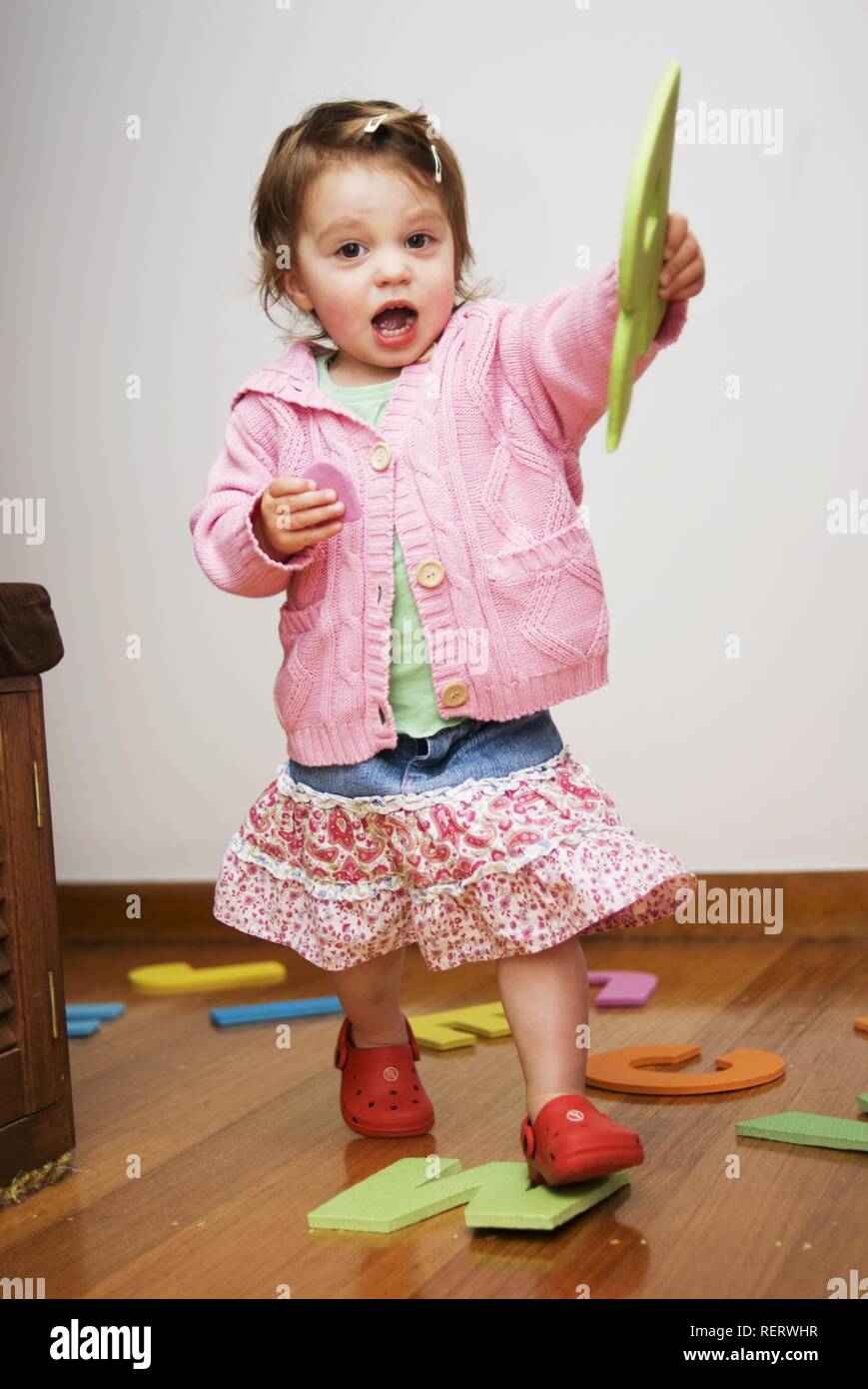 Due anni di ragazza che gioca con grande alfabeto di schiuma lettere Foto Stock