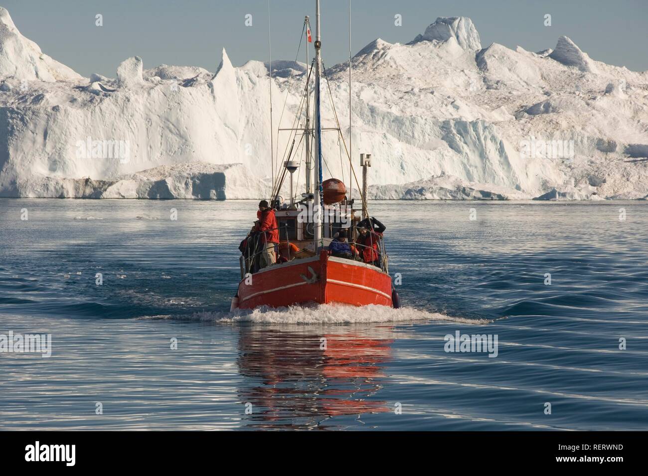 Barca da pesca di fronte iceberg nella baia di Disko, Sito Patrimonio Mondiale dell'UNESCO, Ilulissat, Jakobshavn, Groenlandia, Danimarca Foto Stock