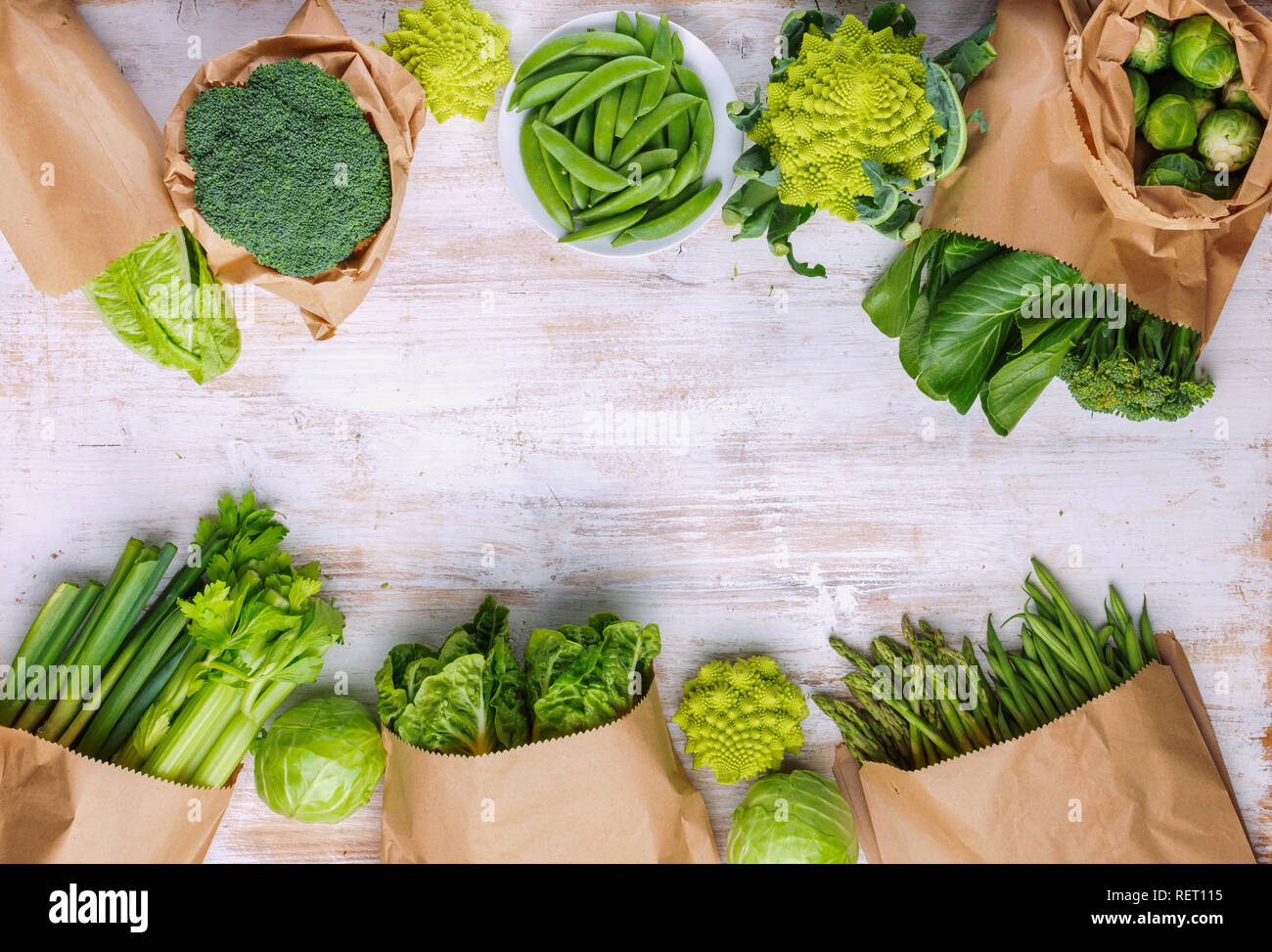 Mangiare sano, copia dello spazio. Mercato degli agricoltori di produrre in sacchetti di carta. Verdure verdi sul tavolo bianco, broccoletti piselli avocado sedano zucchine bok Foto Stock