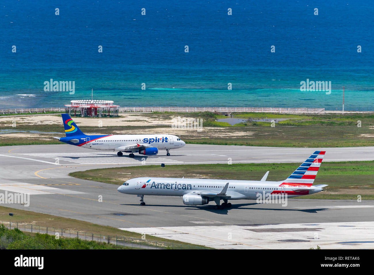 Montego Bay, Giamaica - 27 Marzo 2015: spirito Airlines e American Airlines aeromobili la preparazione per la partenza dall'Aeroporto Internazionale di Sangster Foto Stock