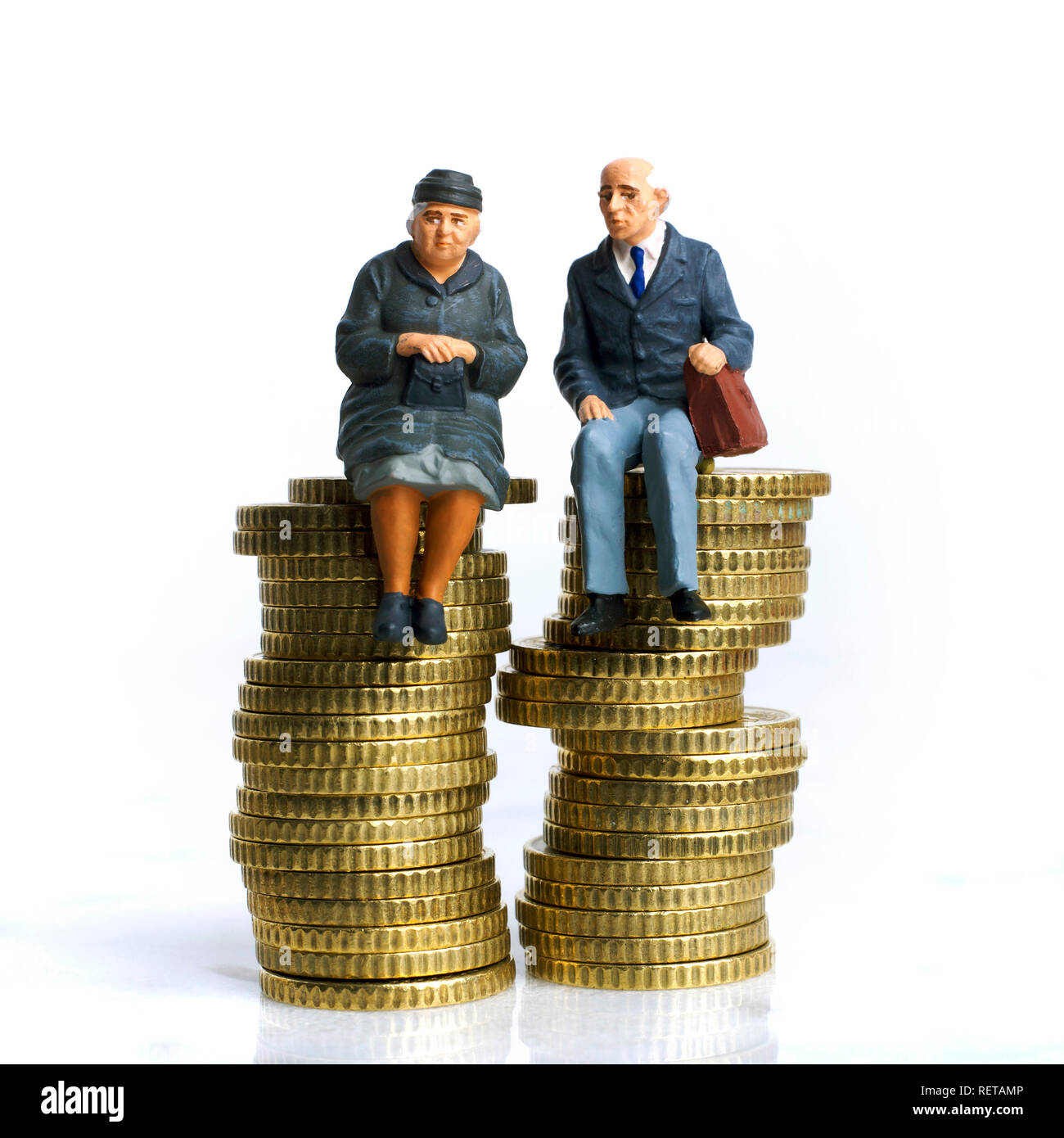 Immagine simbolo della pensione, coppia di anziani, figurine seduti sulla pila di monete Foto Stock