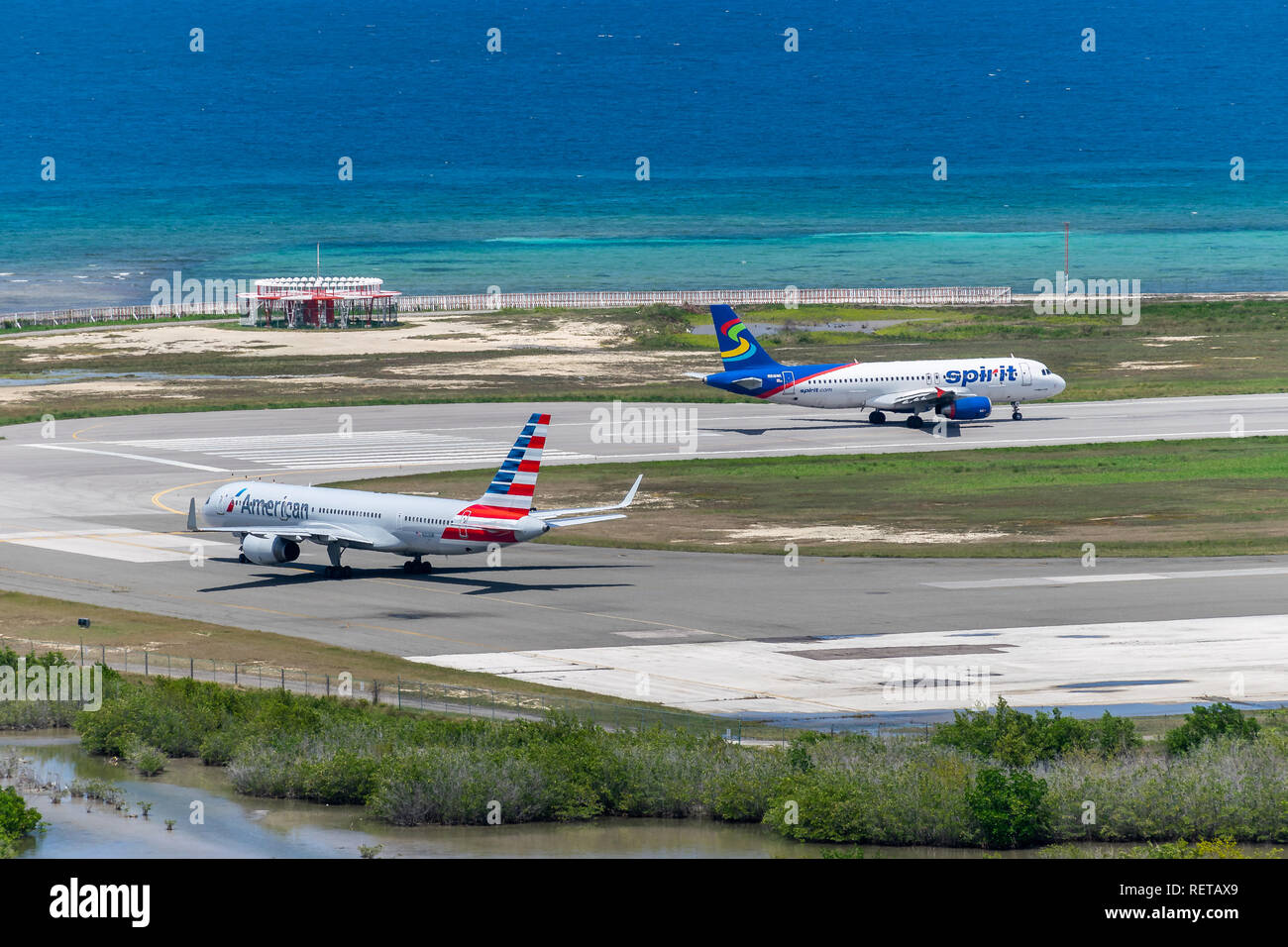 Montego Bay, Giamaica - 27 Marzo 2015: spirito Airlines e American Airlines aeromobili la preparazione per la partenza dall'Aeroporto Internazionale di Sangster Foto Stock