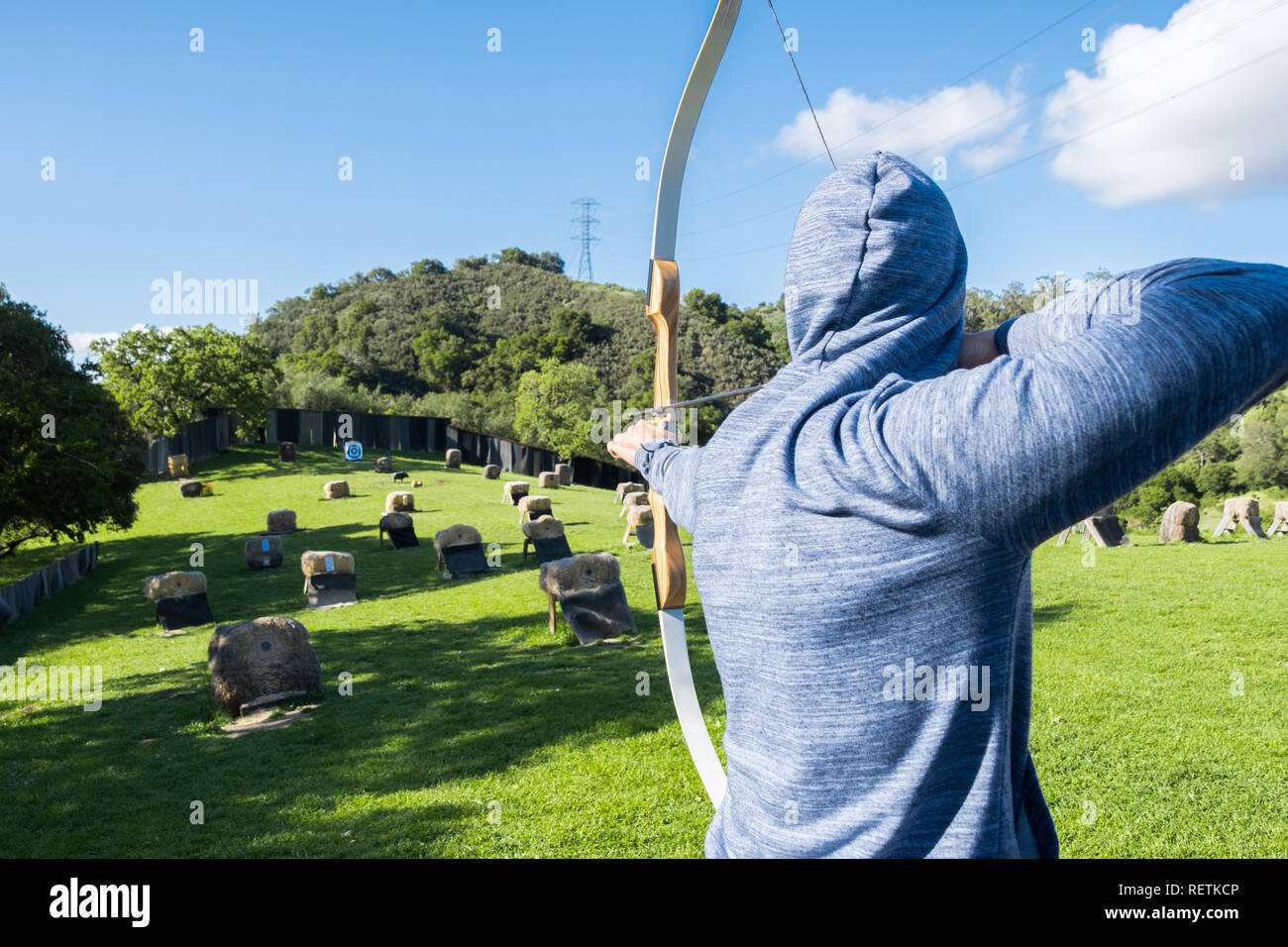 Persona non identificata praticare il tiro con l'arco; Foto Stock