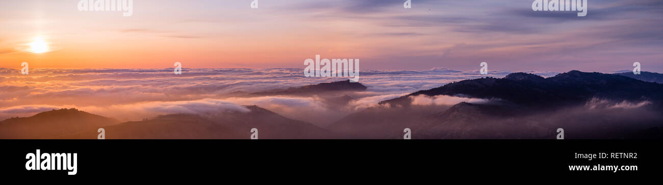 Vista panoramica di un tramonto su un mare di nuvole che copre South San Francisco Bay Area; le creste della montagna in primo piano; vista da Mt Hamilton, San J Foto Stock