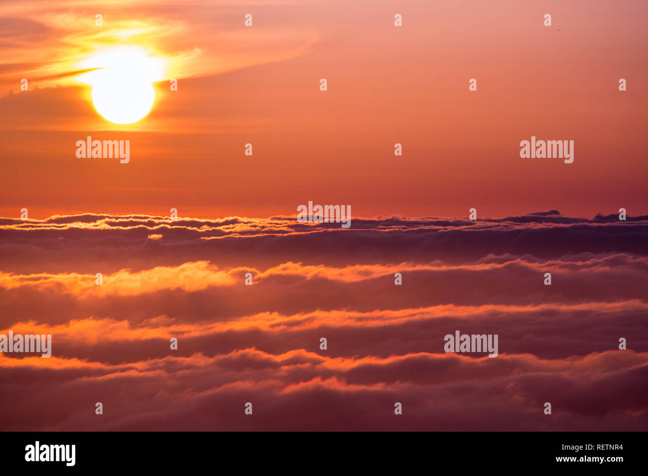 La luminosa luce del sole riflessa su un mare di nuvole prima del tramonto Foto Stock