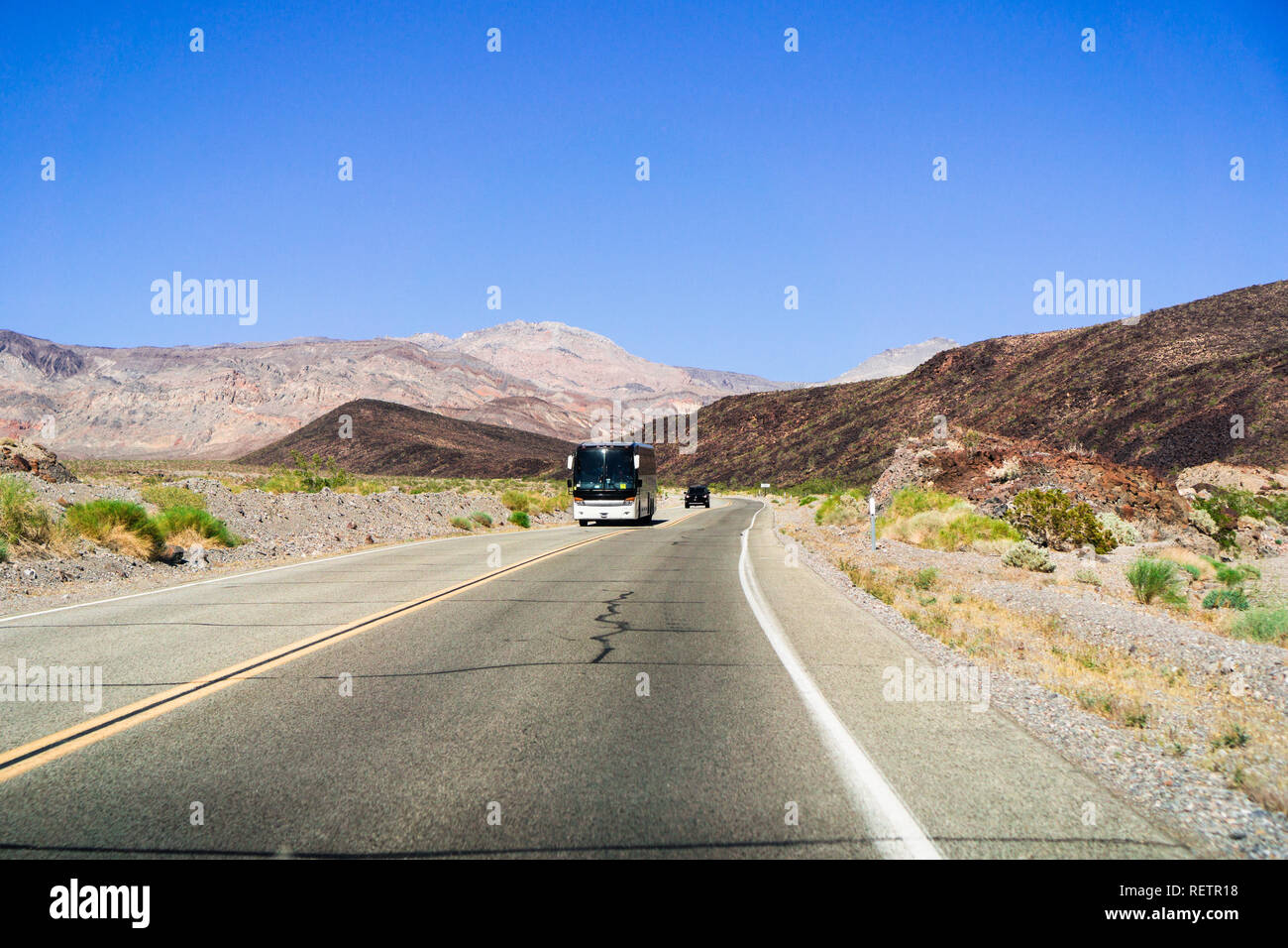 Tour bus guidando attraverso il Parco Nazionale della Valle della Morte, California Foto Stock