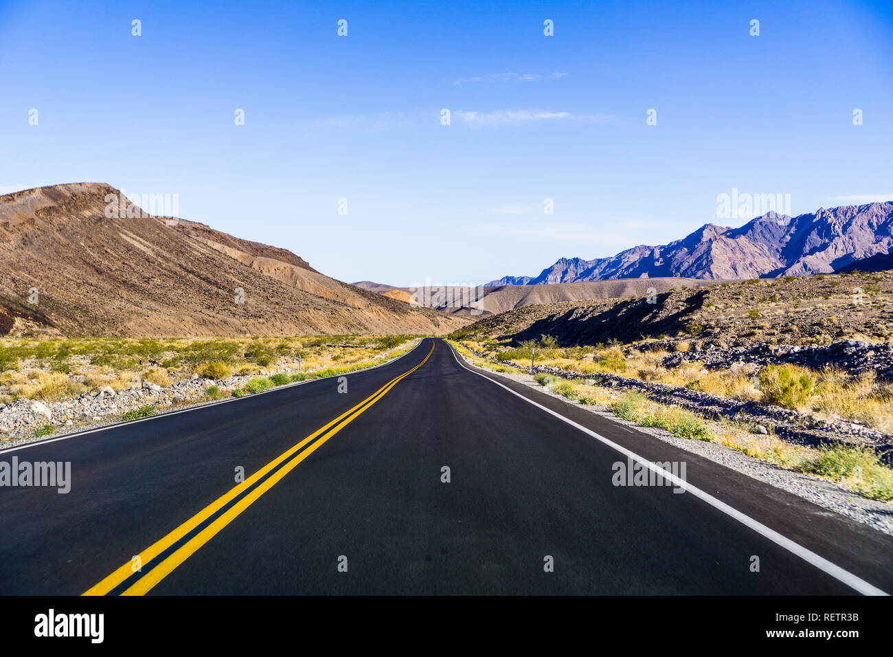 Vista la mattina dell'autostrada attraversando il Parco nazionale della Death Valley, California Foto Stock