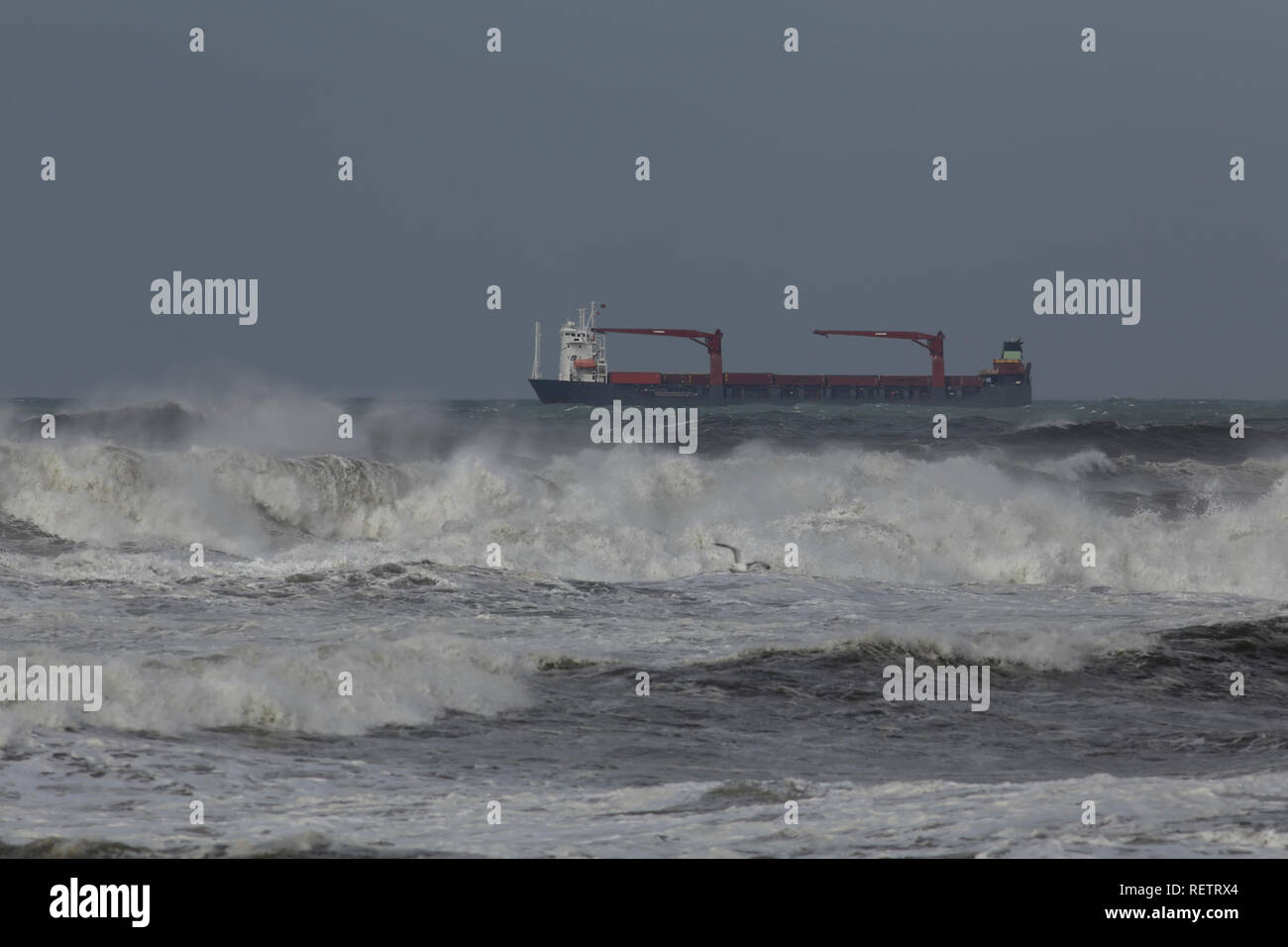 Contenitore nave che attraversa la costa portoghese durante la tempesta. Foto Stock