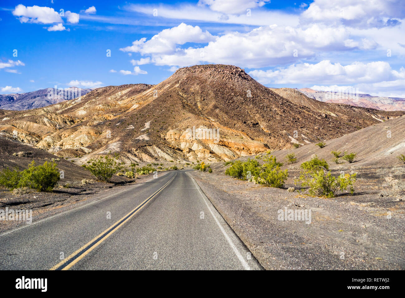 Autostrada passando attraverso le pittoresche montagne del Parco Nazionale della Valle della Morte, California Foto Stock